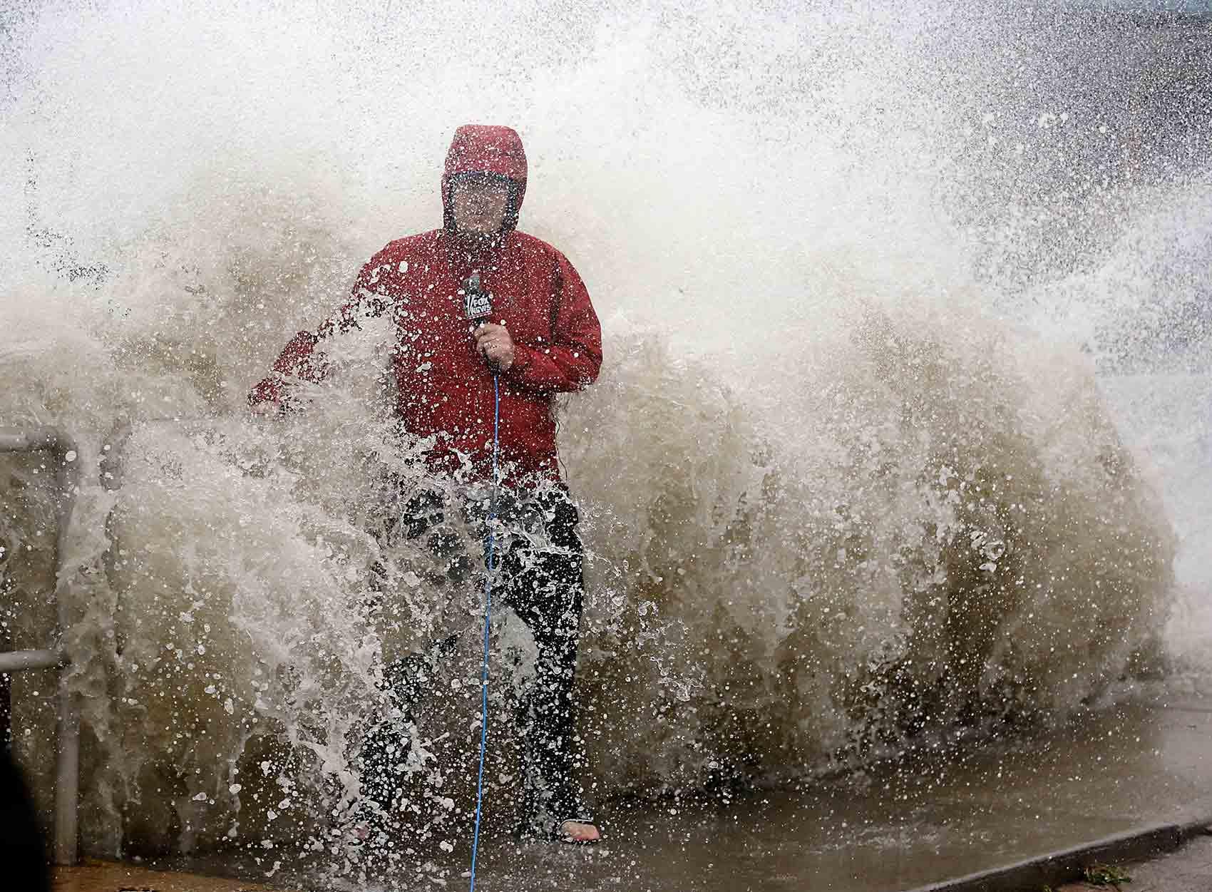 En nyhetsreporter överraskas av en våg när orkanen Hermine drar in mot Floridas kust.
