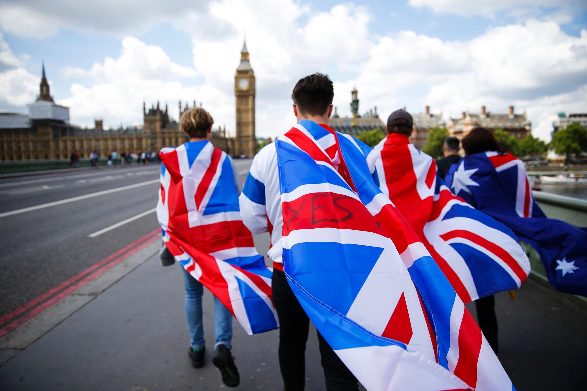 En grupp går mot Big Ben med bland annat Storbritanniens flagga.