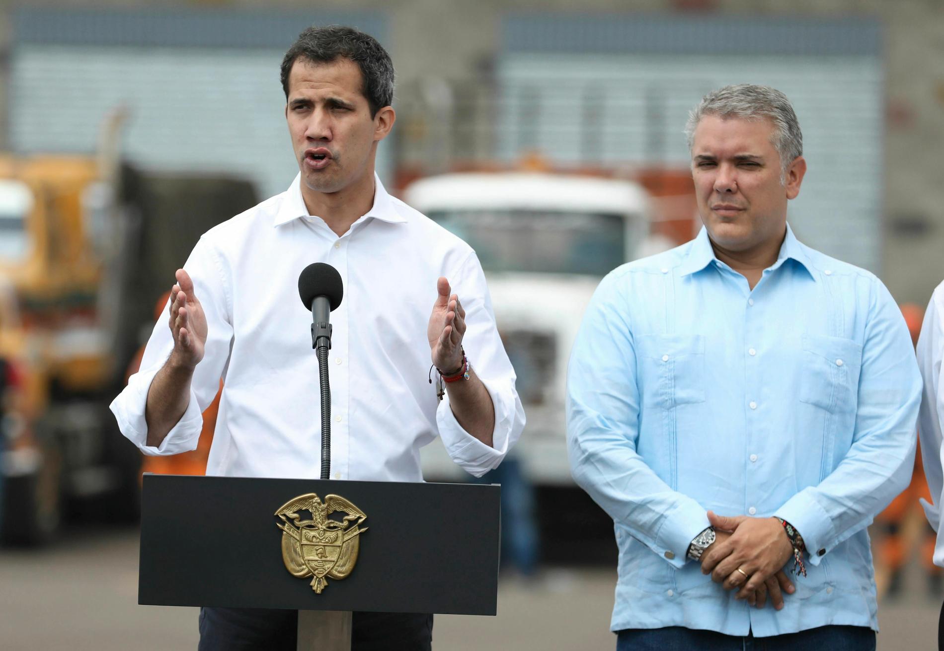 Juan Guaidó (till vänster) tog sig till Colombia i helgen. Här talar han på lördagen, med Colombias president Iván Duque vid sin sida, framför de lager i Cúcuta, Colombia, som inrymmer mat och mediciner som man försöker föra in i Venezuela.