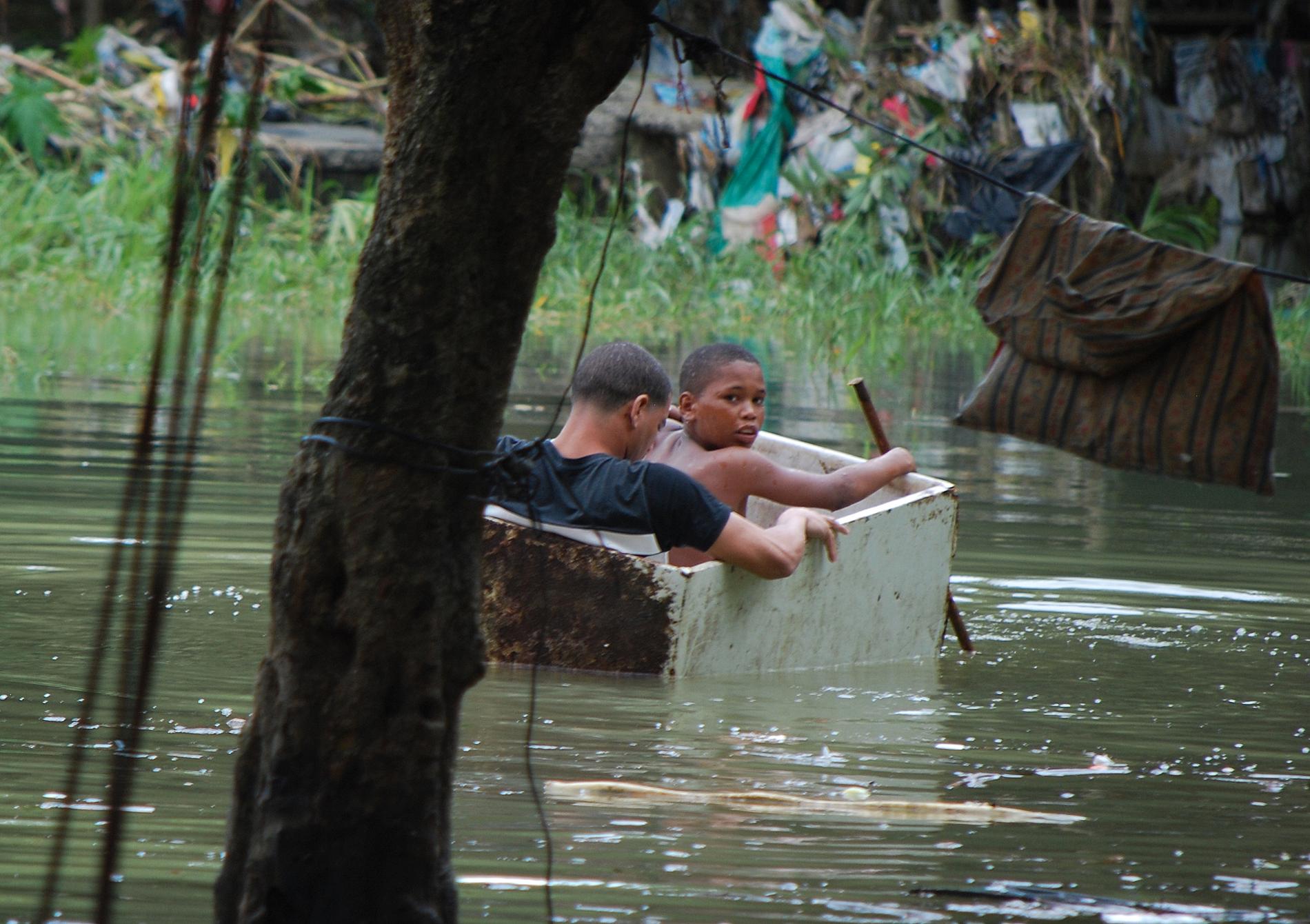 Ett par barn passar på att leka i översvämningsvattnet i Santo Domingo, Dominikanska Republiken.