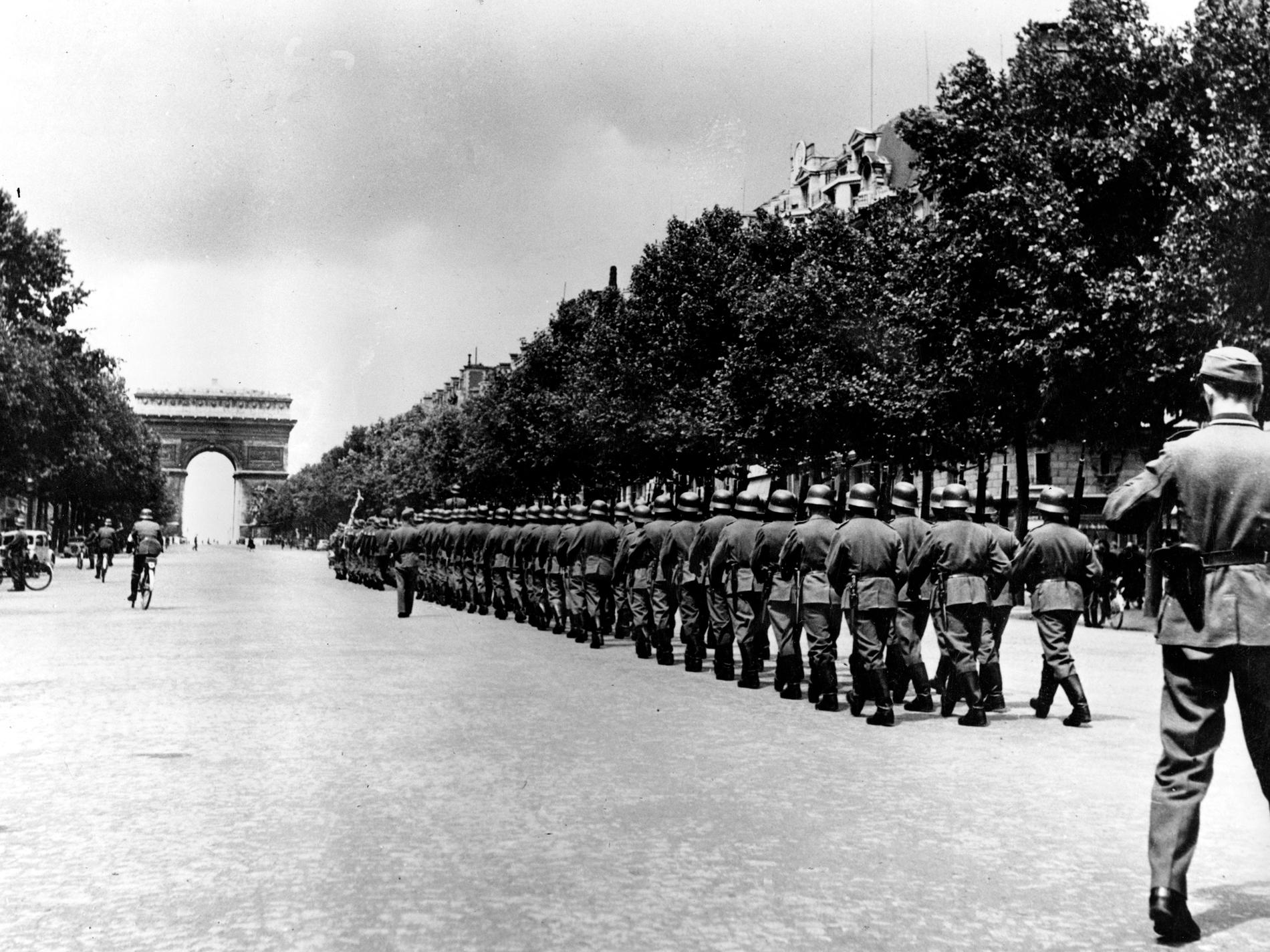 En fransk man vars far tvingades strida för Nazityskland kräver tysk ersättning för sin föräldralöshet. På bilden marscherar tyska soldater på Champs-Élysées, Paris, i september 1944. Arkivbild.