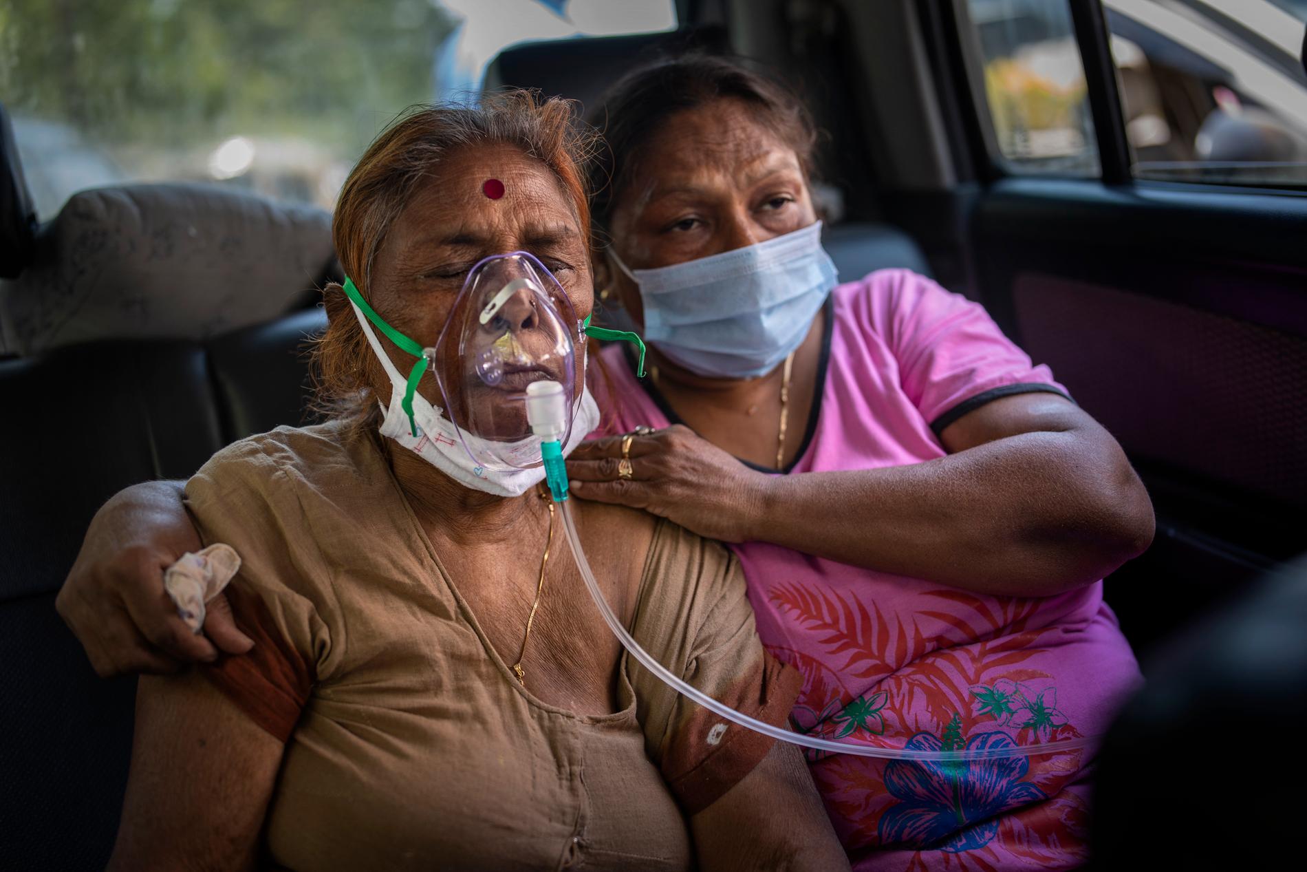 En covid-patient andas syrgas i en bil i Delhi. 