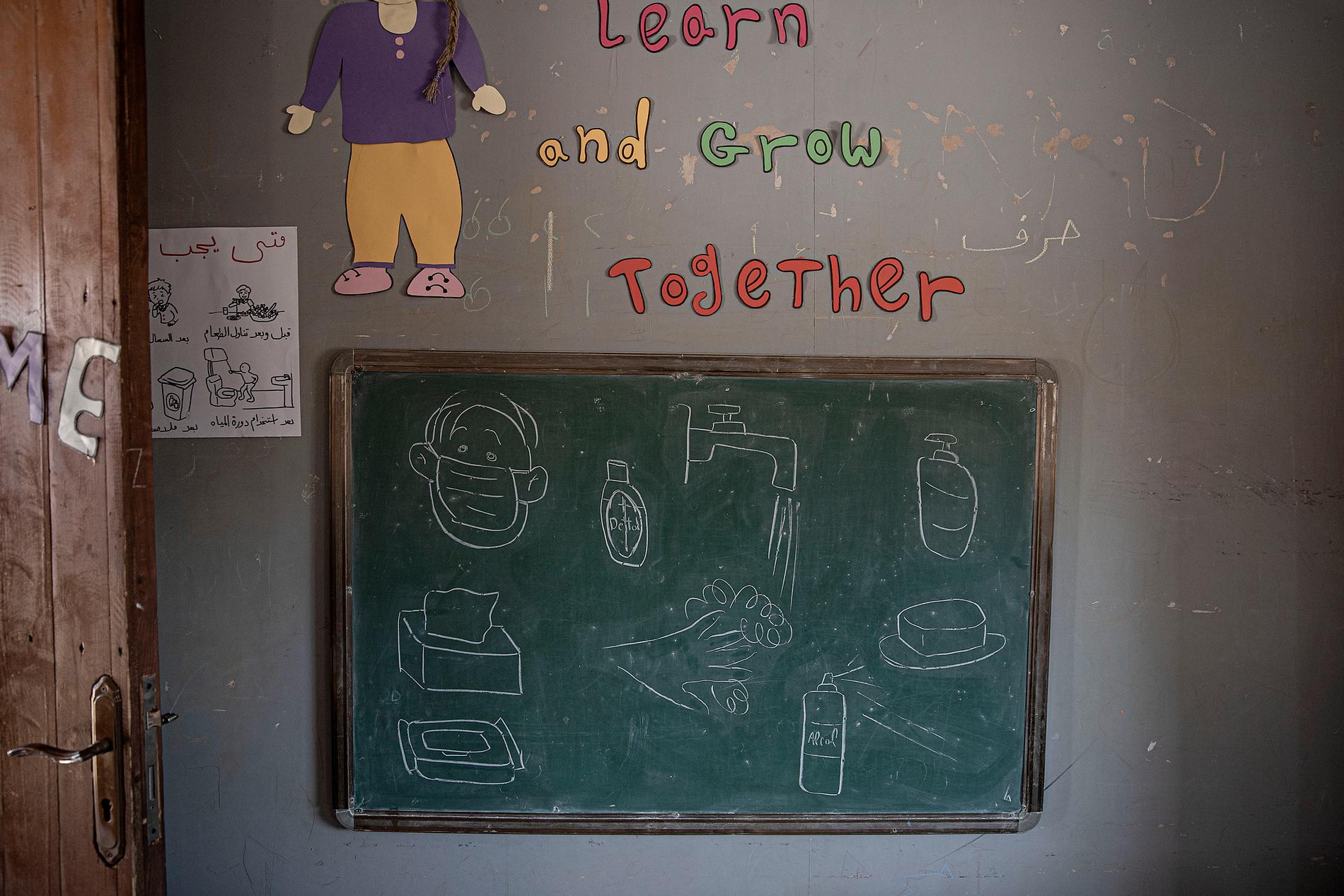 En tavla i klassrummet med teckningar på bland annat ett par händer som tvättas och munskydd.