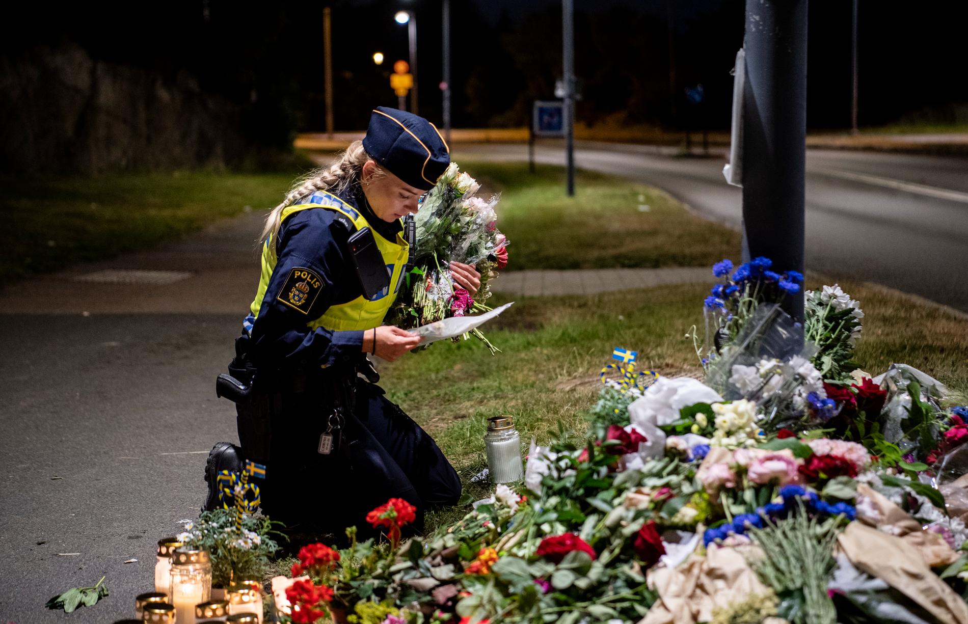 En kollega lägger ned blommor vid platsen där polisen Andreas Dalman mördades.