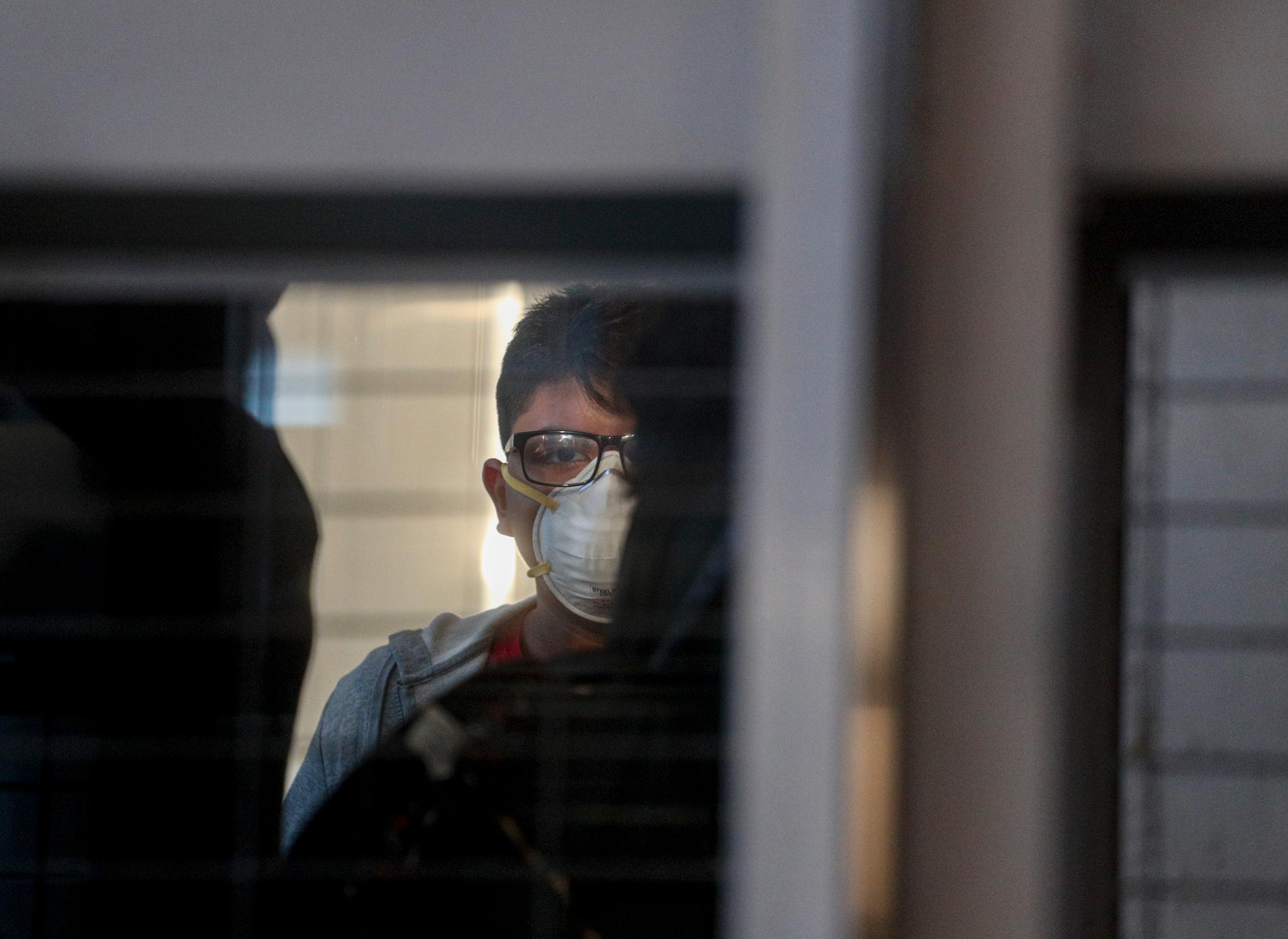 En passagerare med skyddsmask vid Arturo Benítez-flygplatsen, Santiago, Chile. Arkivbild.