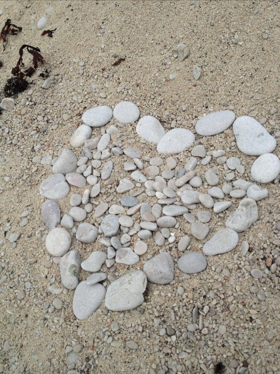 Ett hjärta av stenar på stranden.
