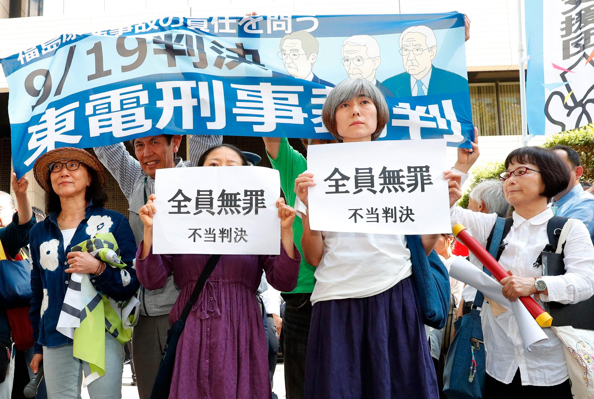 En grupp demonstranter utanför domstolen i Tokyo protesterar mot vad de beskriver som en "orättvis dom".