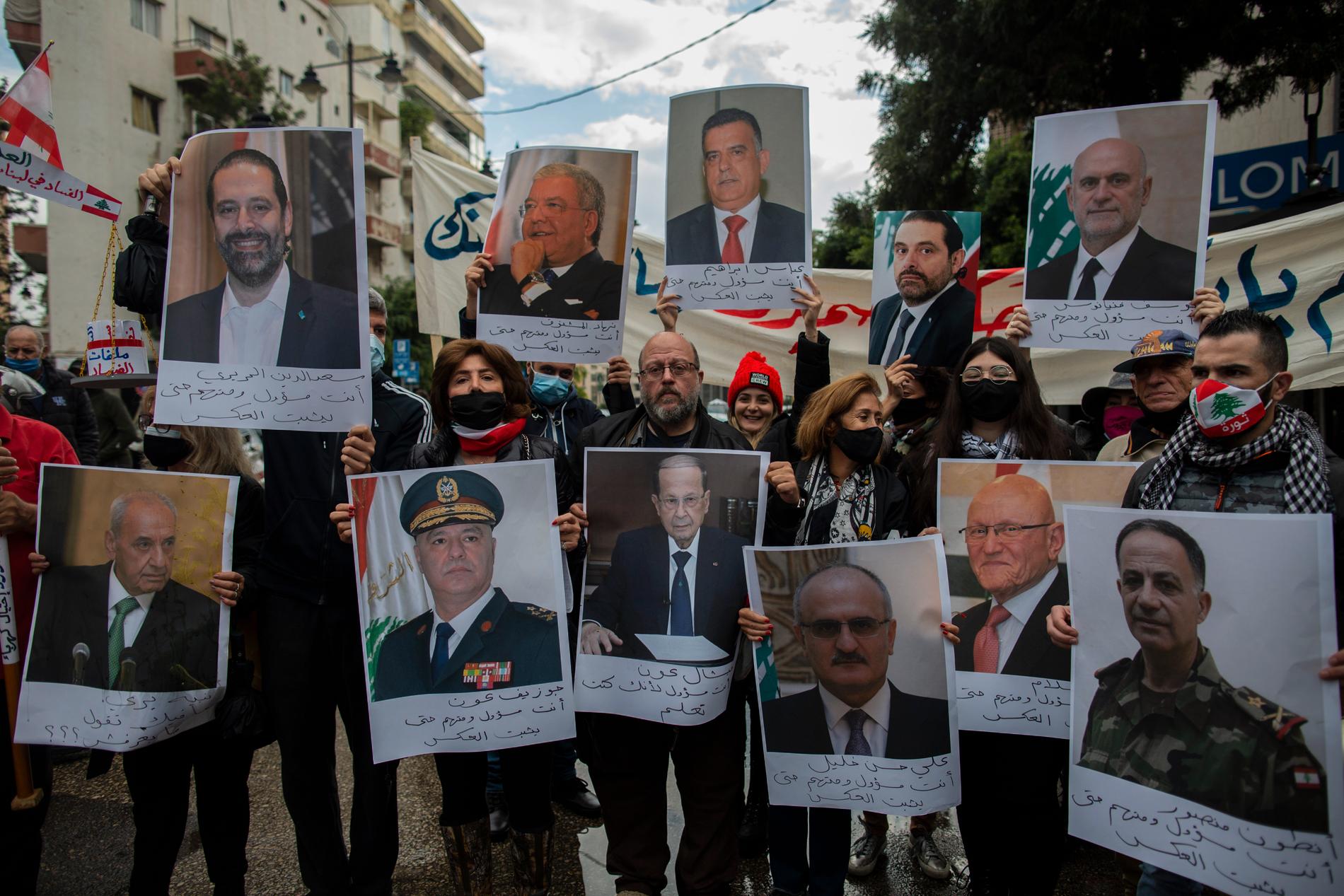 Demonstranter håller i bilder av libanesiska ledare under en protest i Beirut i slutet av november.