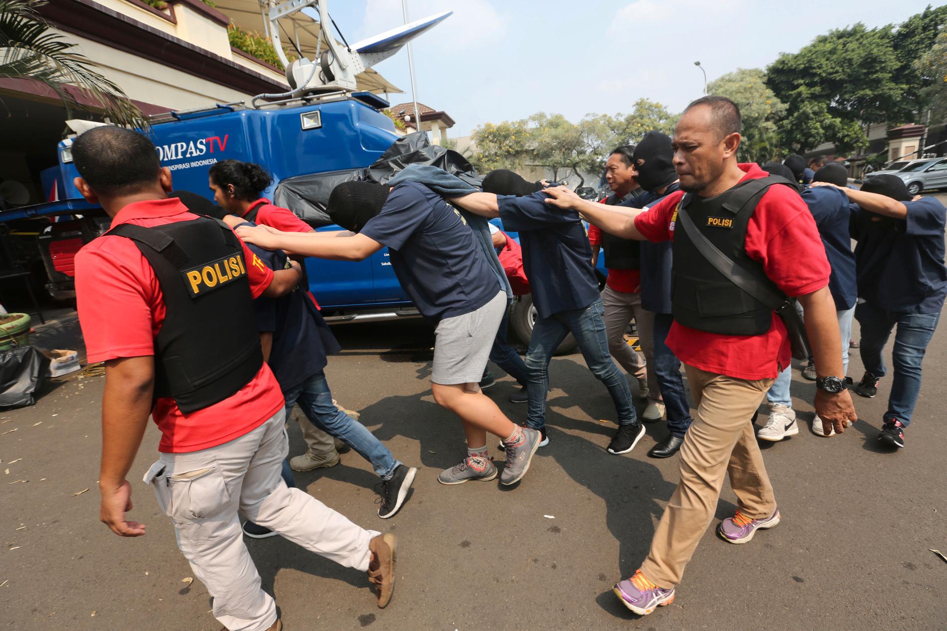 Indonesiska poliser för bort män gripna i en räd mot en bastukubb i Jakarta. Bilden är från 2017. Arkivbild.