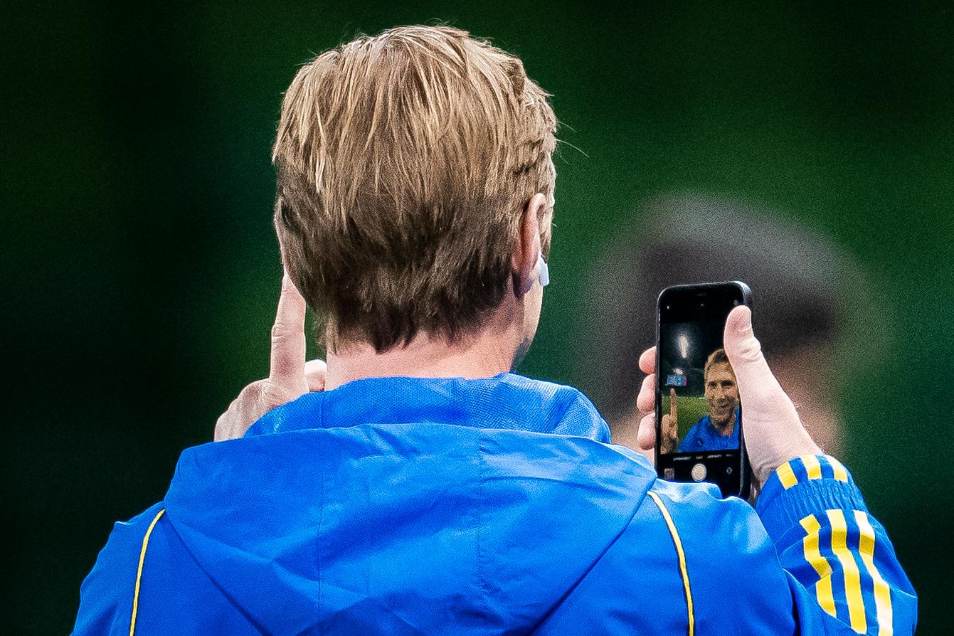 Rasmus Liljeblad, fotbollspsykologisk rådgivare, tar en selfie med resultattavlan i bakgrunden efter vinsten. 