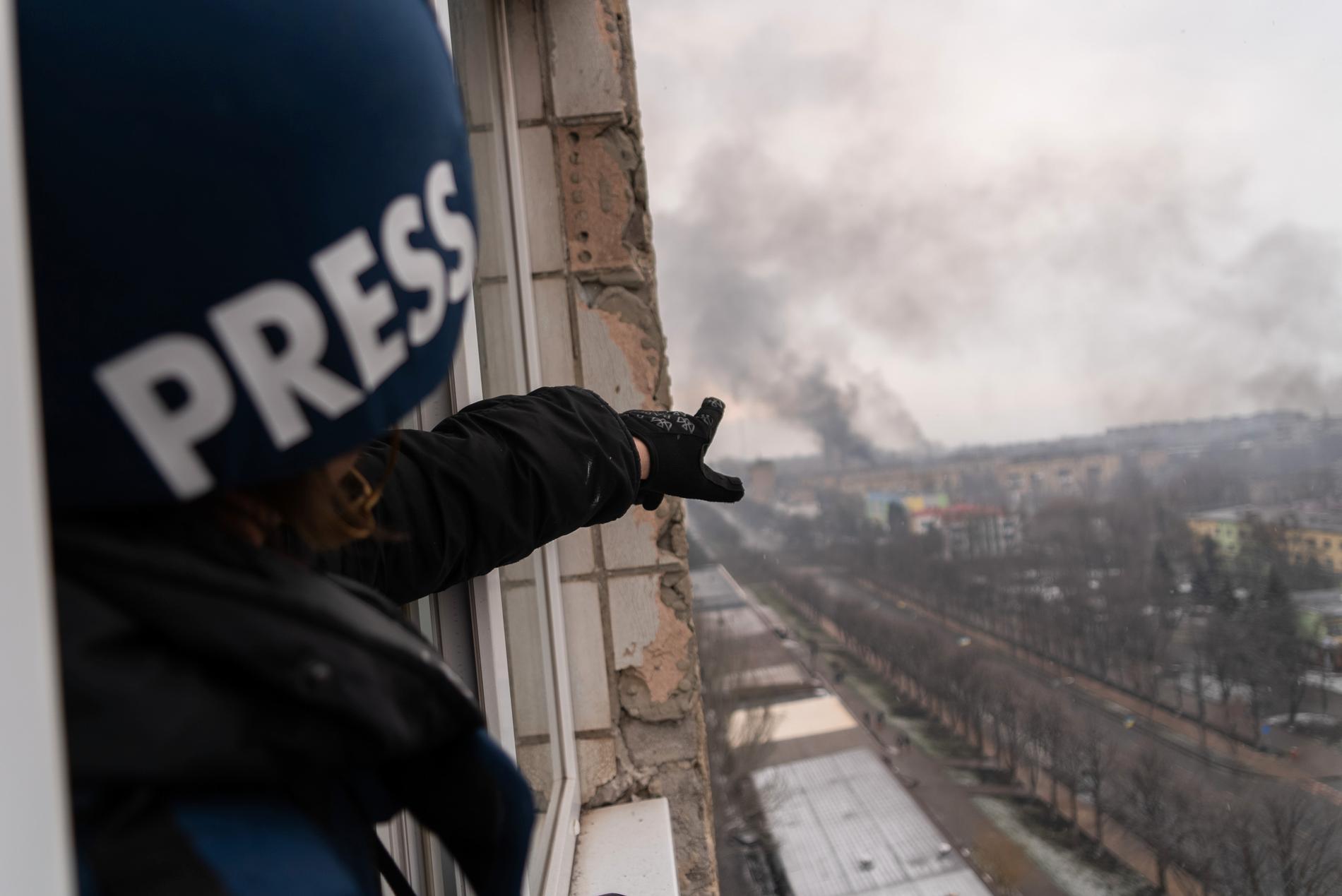 Fotografen Evgeniy Maloletka pekar mot röken som stiger från förlossningssjukhuset som bombades i ett ryskt flyganfall, den 9 mars 2022. Bild från filmen “20 Days in Mariupol.”     