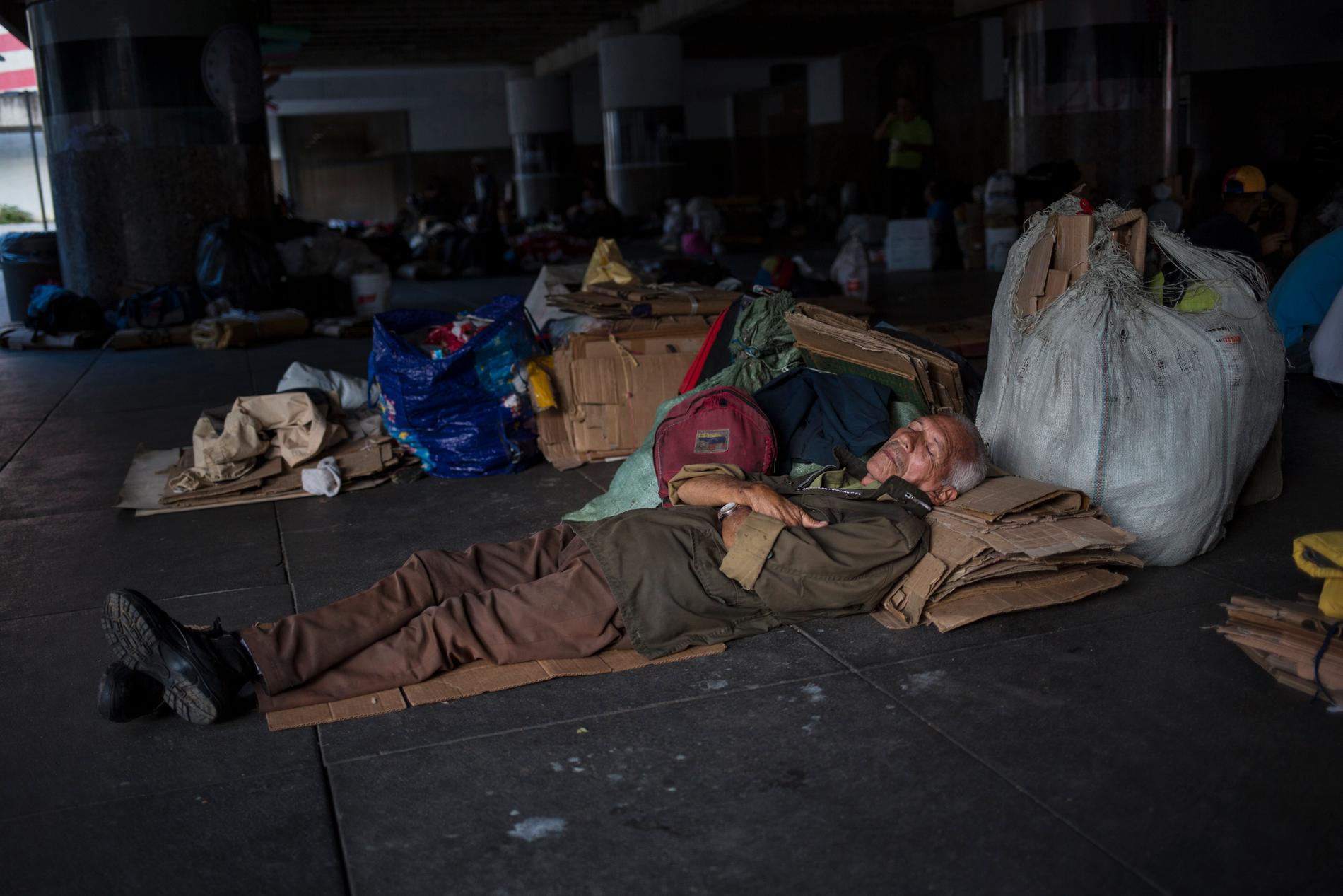 En man sover utanför Venezuelas centralbank i Caracas i protest mot att oljearbetare inte fått sina pensioner utbetalda. Bild från den 16 juli.