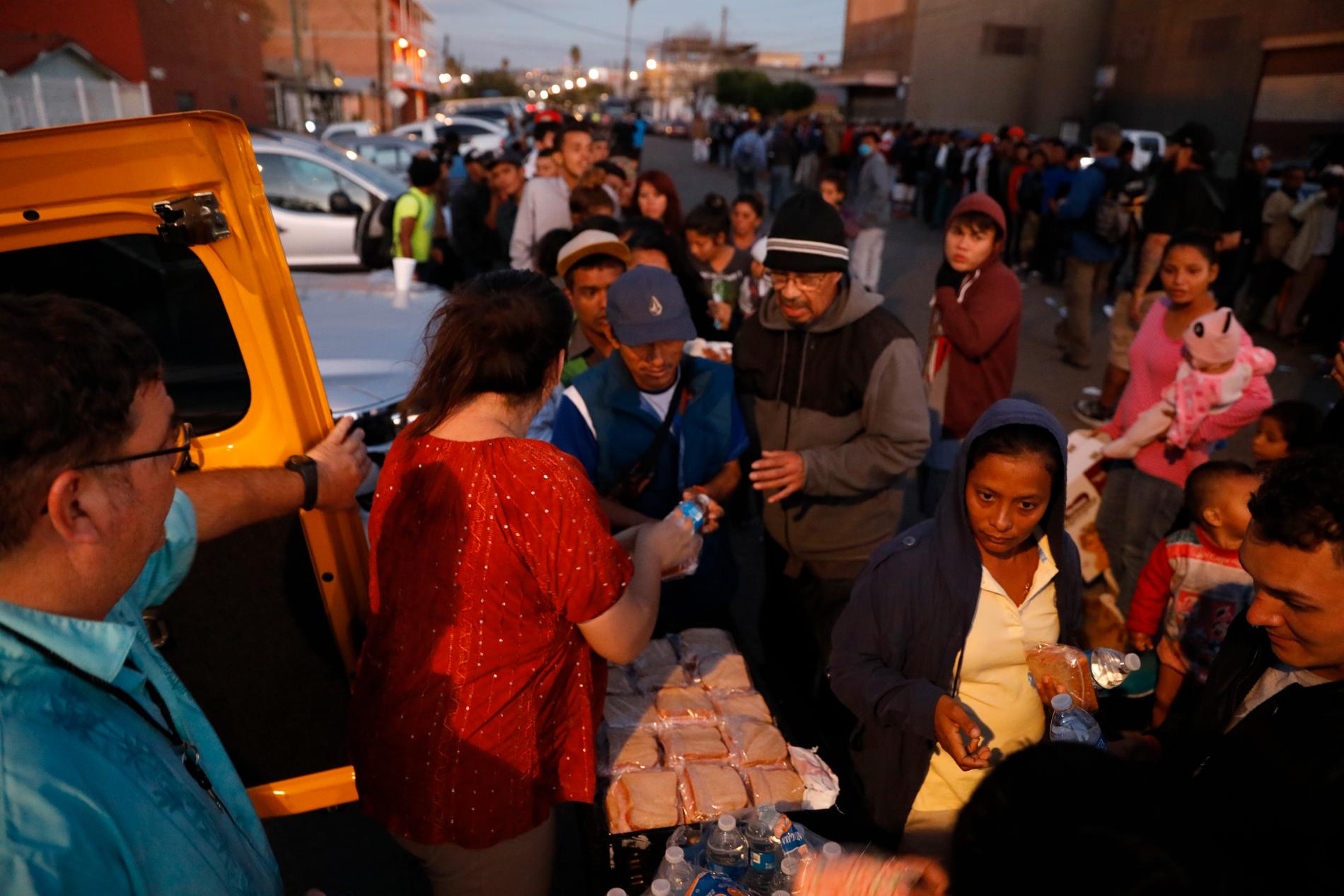 Volontärer delar ut mat till migranter i Tijuana i Mexiko. Fler än 6 000 migranter på flykt från våldsamheter och fattigdom i bland annat Honduras har anlänt till staden med förhoppningar om att beviljas asyl i USA.