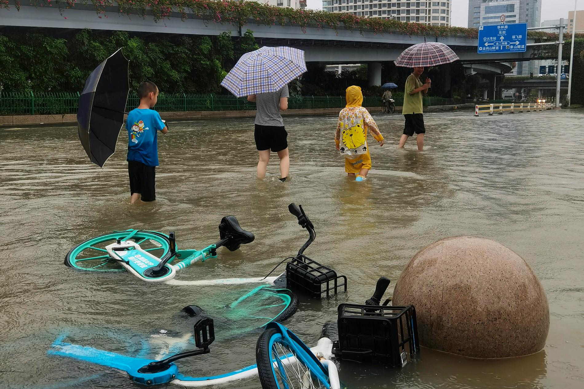 Människor vadar genom vattenmassorna i Fuzhou.