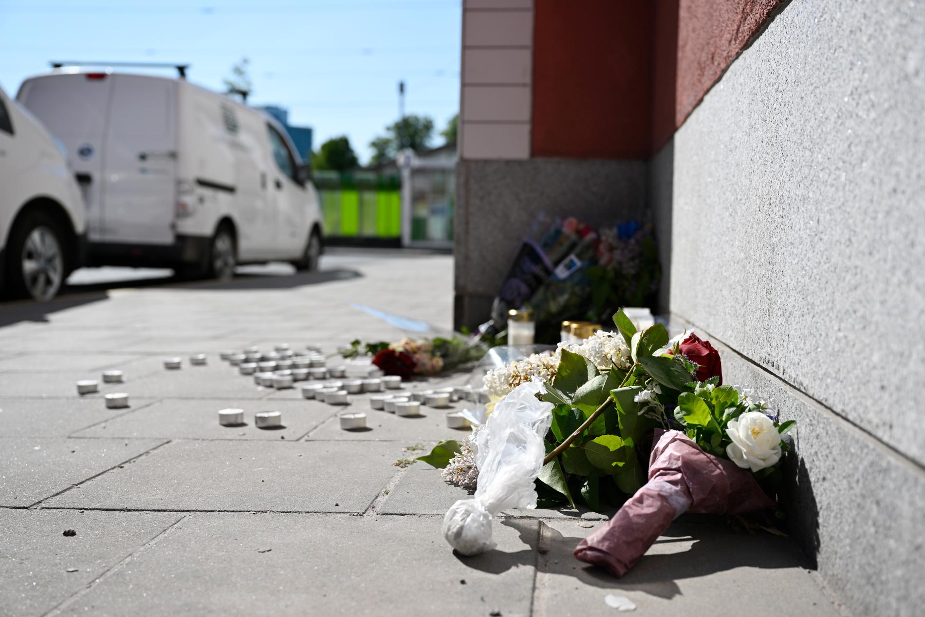 Blommor vid platsen i Älvsjö där en pojke knivmördades början av juni förra året. Arkivbild.