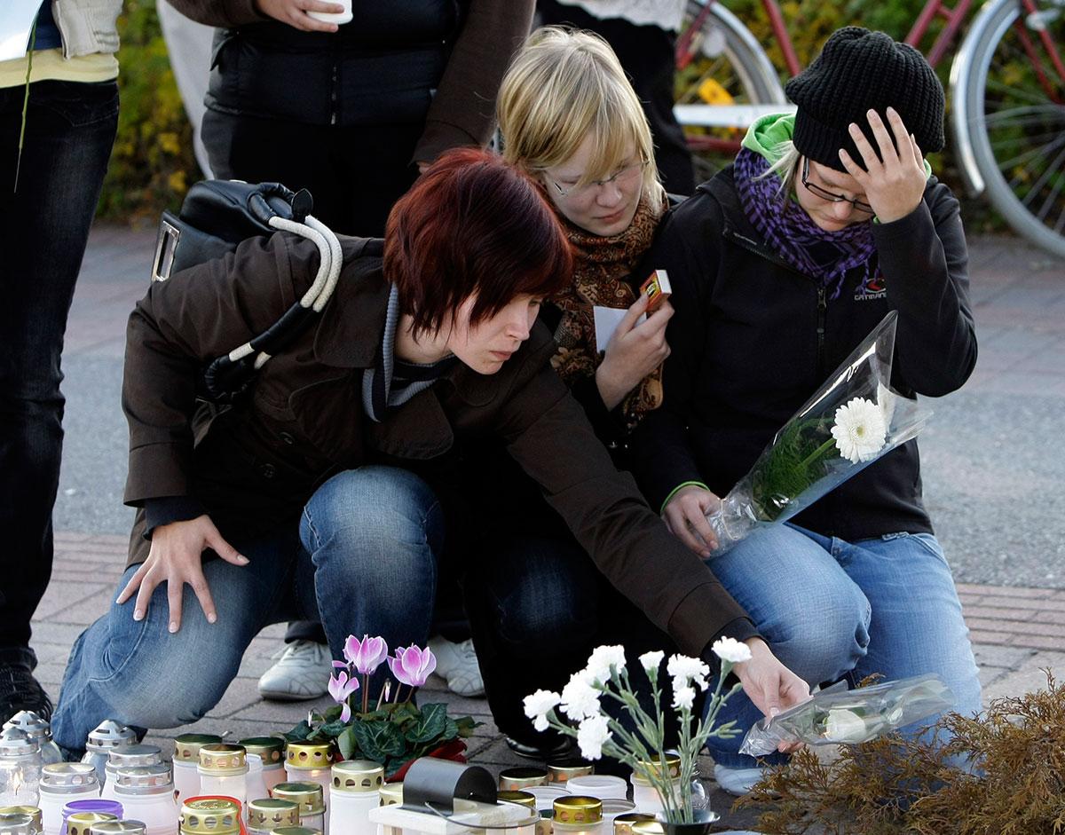 Sörjande lämnar blommor efter skolattacken i Finland.