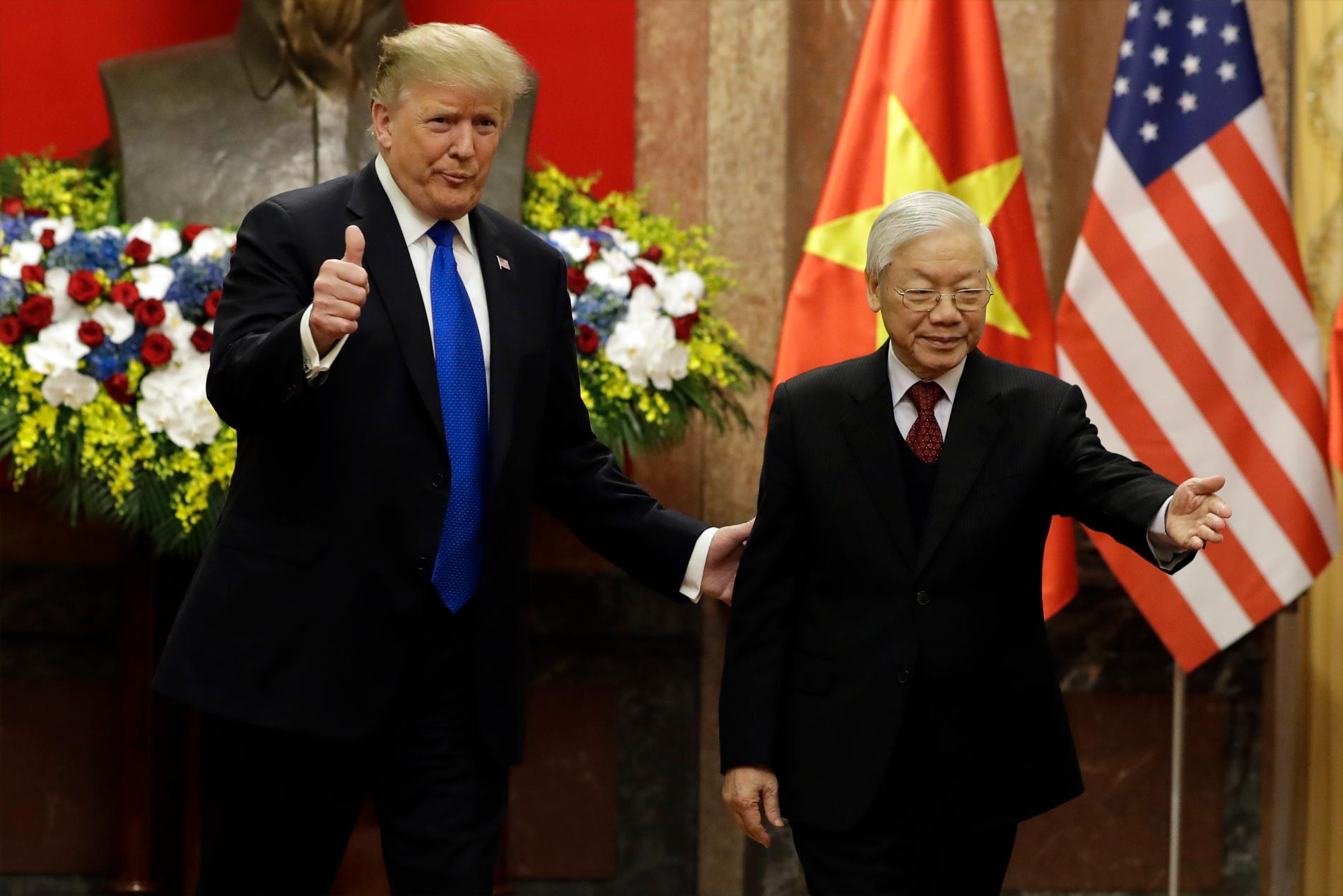 Donald Trump gör tummen upp när han träffar Vietnams president Nguyen Phu Trong.