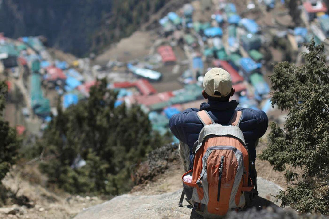 En man blickar ut över sin hemby Namche i Everest-området.