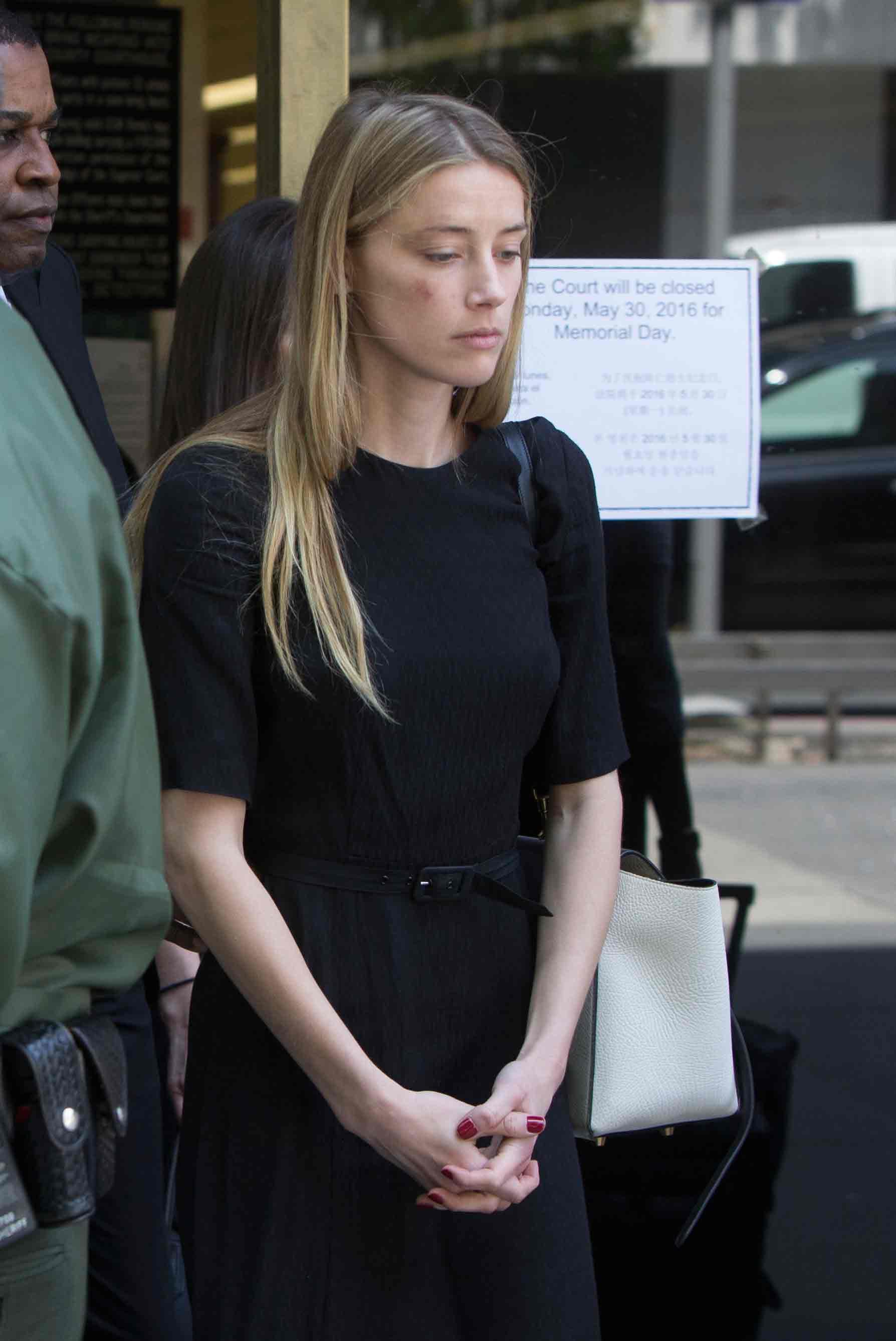 Amber Heard lämnar domstolen i Los Angeles, där hon visade bilder av sig själv blåslagen.