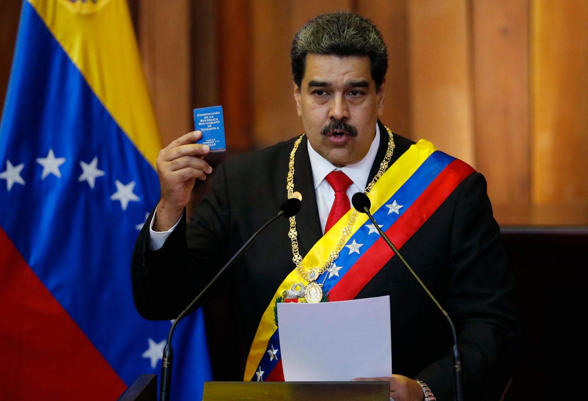 Venezuelas president Nicolas Maduro håller upp en liten kopia av landets konstitution när han svärs in som president.