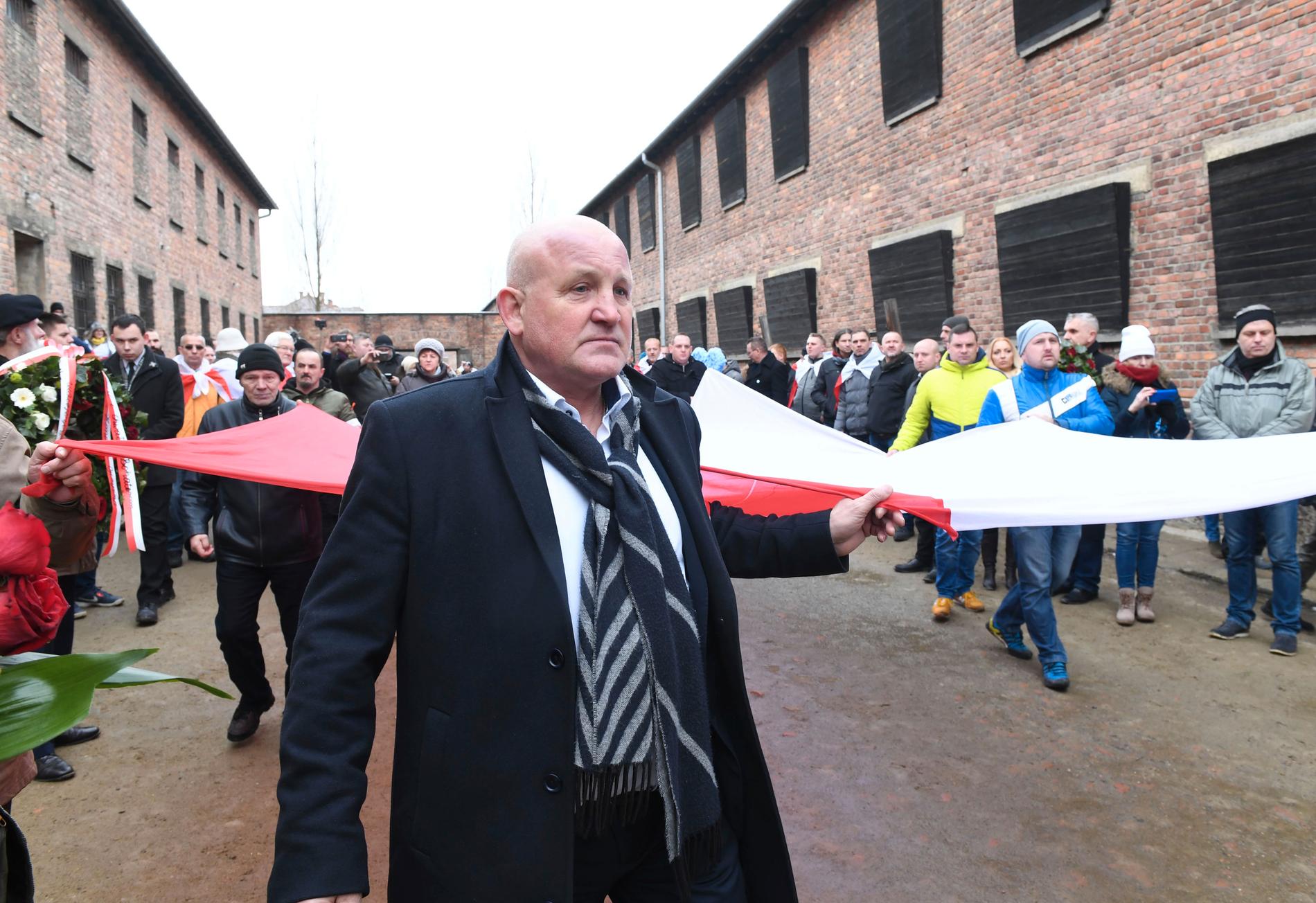 Polska högerextremister bär en stor polsk flagga genom Auschwitz.