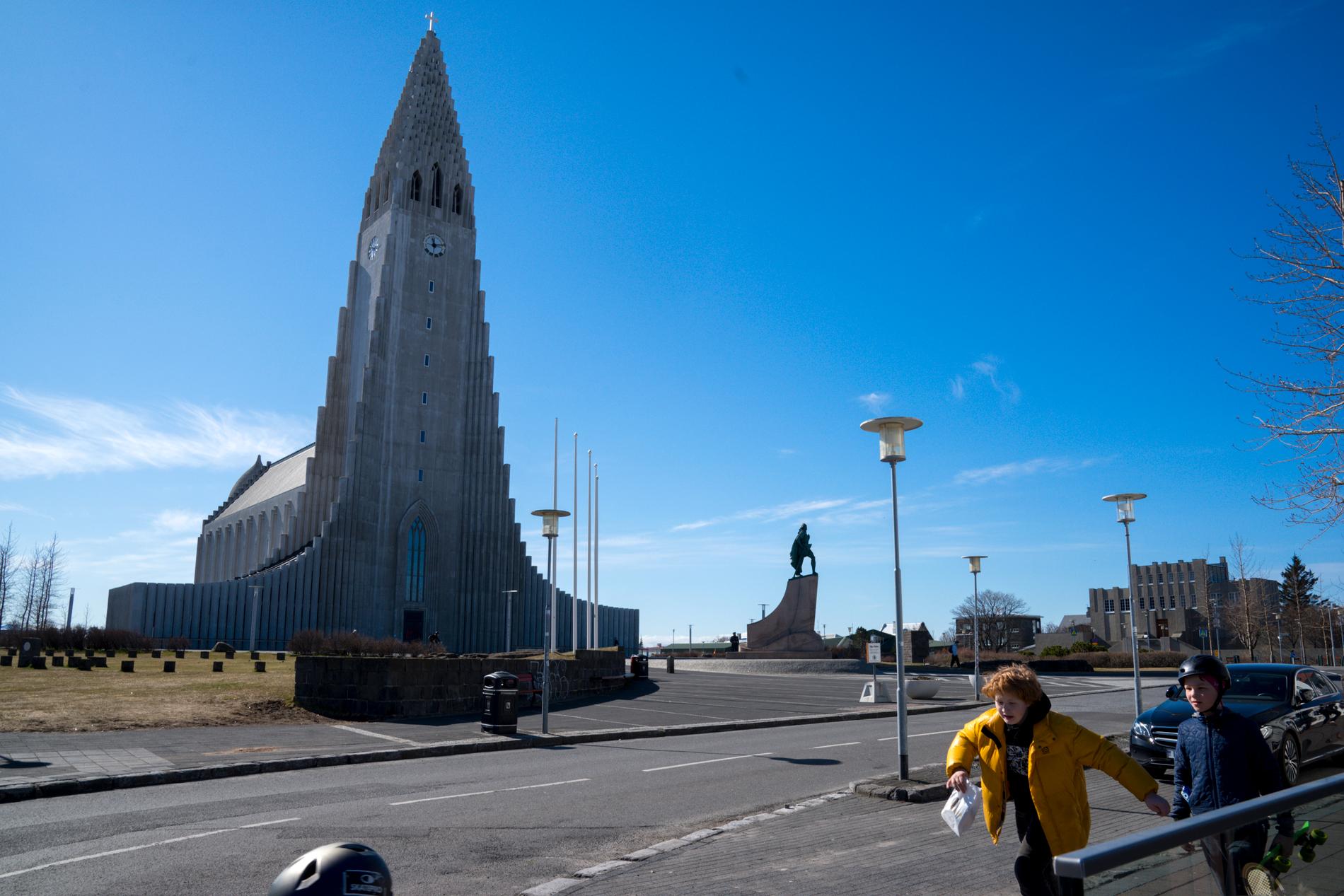 Två pojkar passerar ett tomt torg framför Hallgrímskirkja i Reykjavik i slutet av april, då landet meddelade lättnader i coronarestriktionerna.