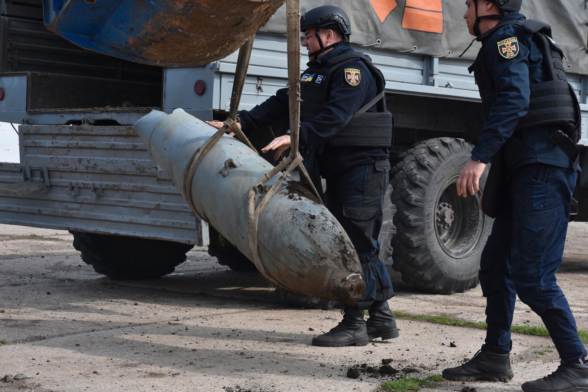 Räddningsarbetare tar hand om en odetonerad bomb av typen FAB-500 i Ukraina.