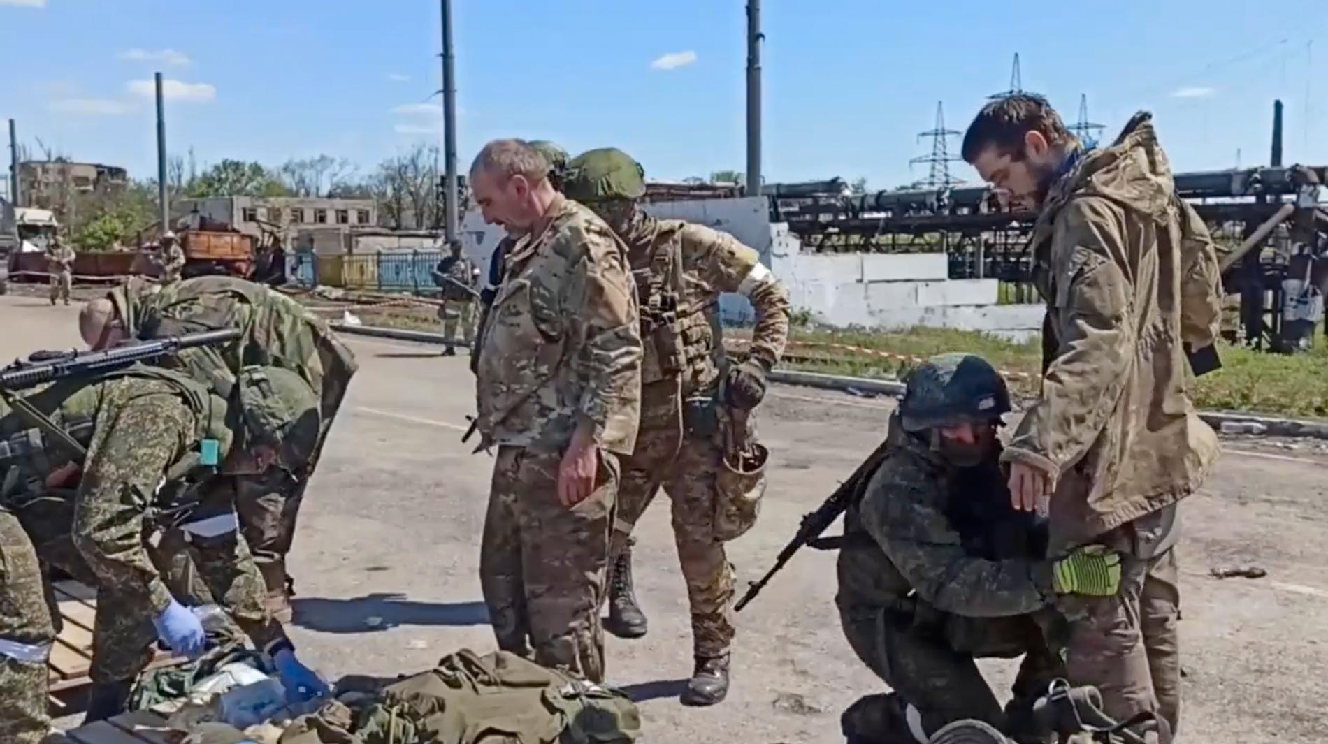 Ukrainska krigsfångar genomsöks av ryska soldater efter att styrkorna inne i Azovstal kapitulerat i maj i år.