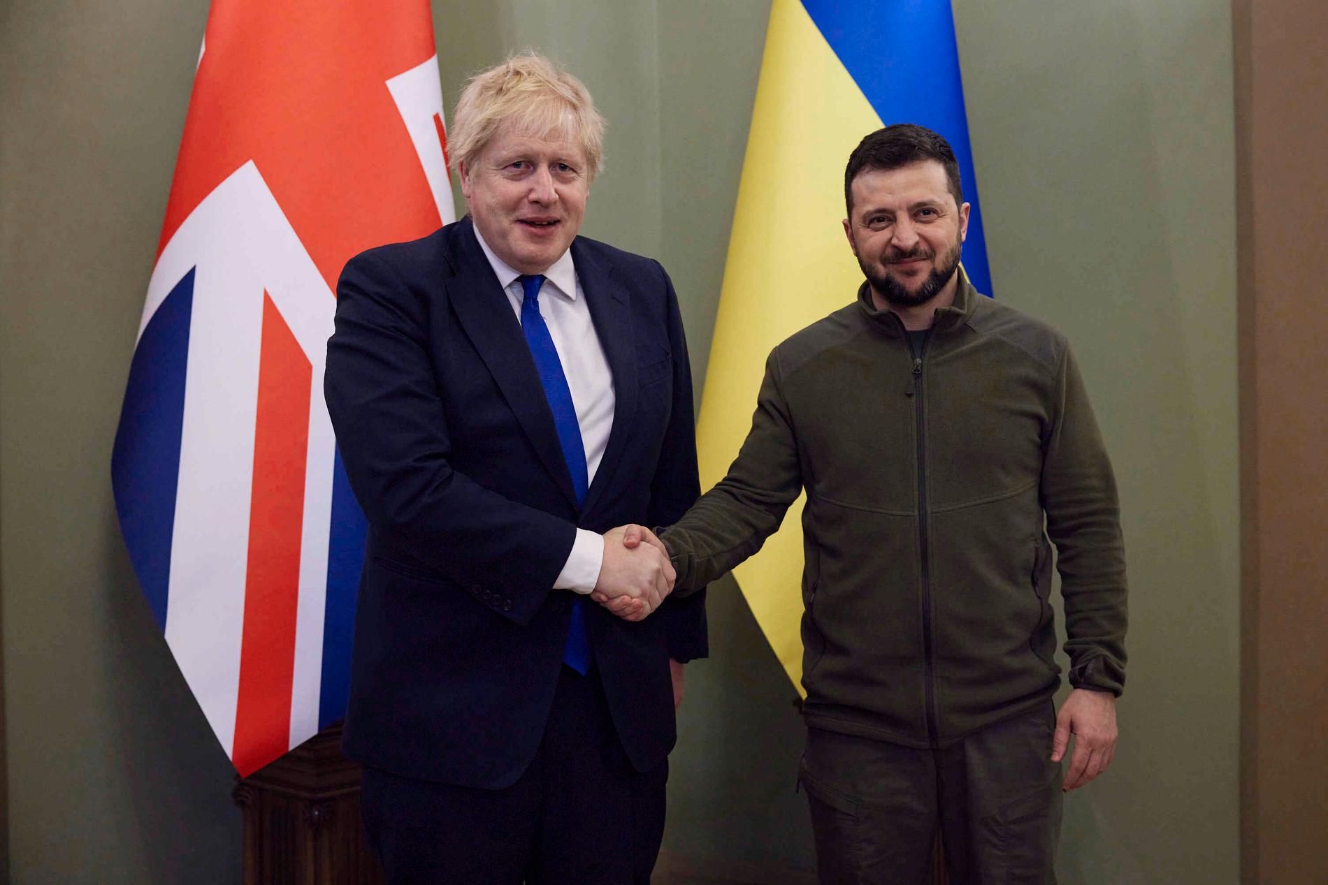 Volodomyr Zelenskyj, i den numera berömda fleecen, skakar hand med Storbritanniens premiärminister Boris Johnson.