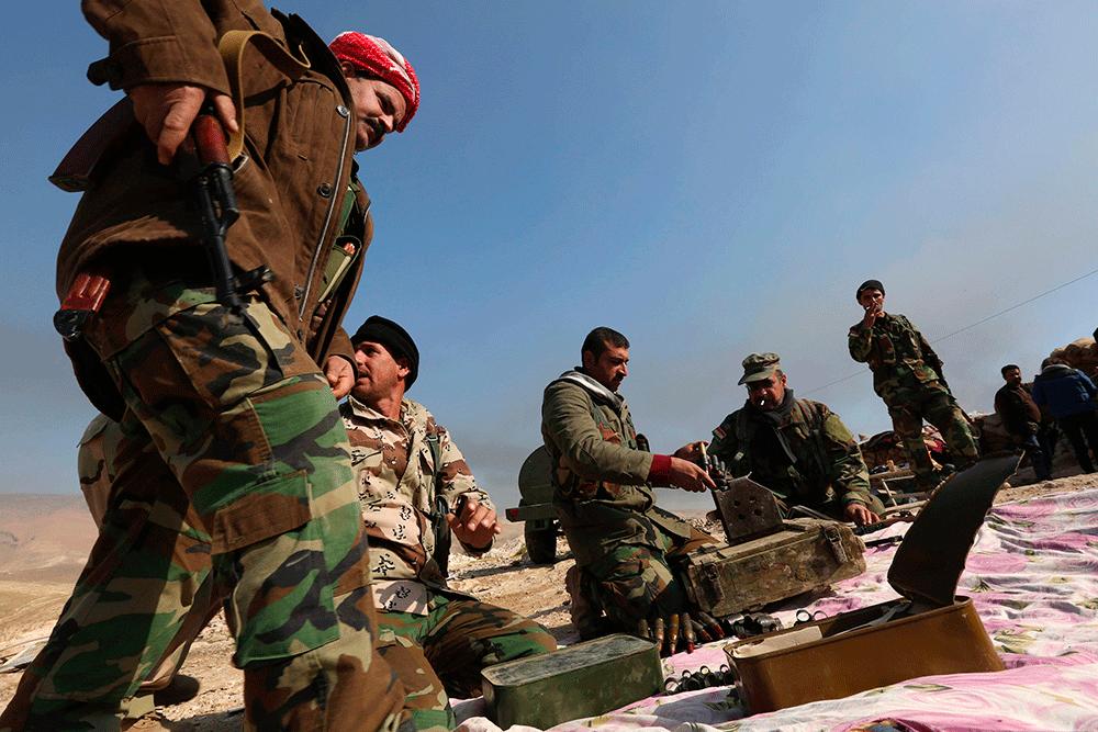 Medlemmar ur kurdiska peshmerga-styrkor kollar sina vapen.