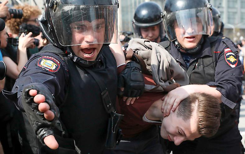 Kravallpolis slår till mot en demonstration i S:t Petersburg i maj i år.