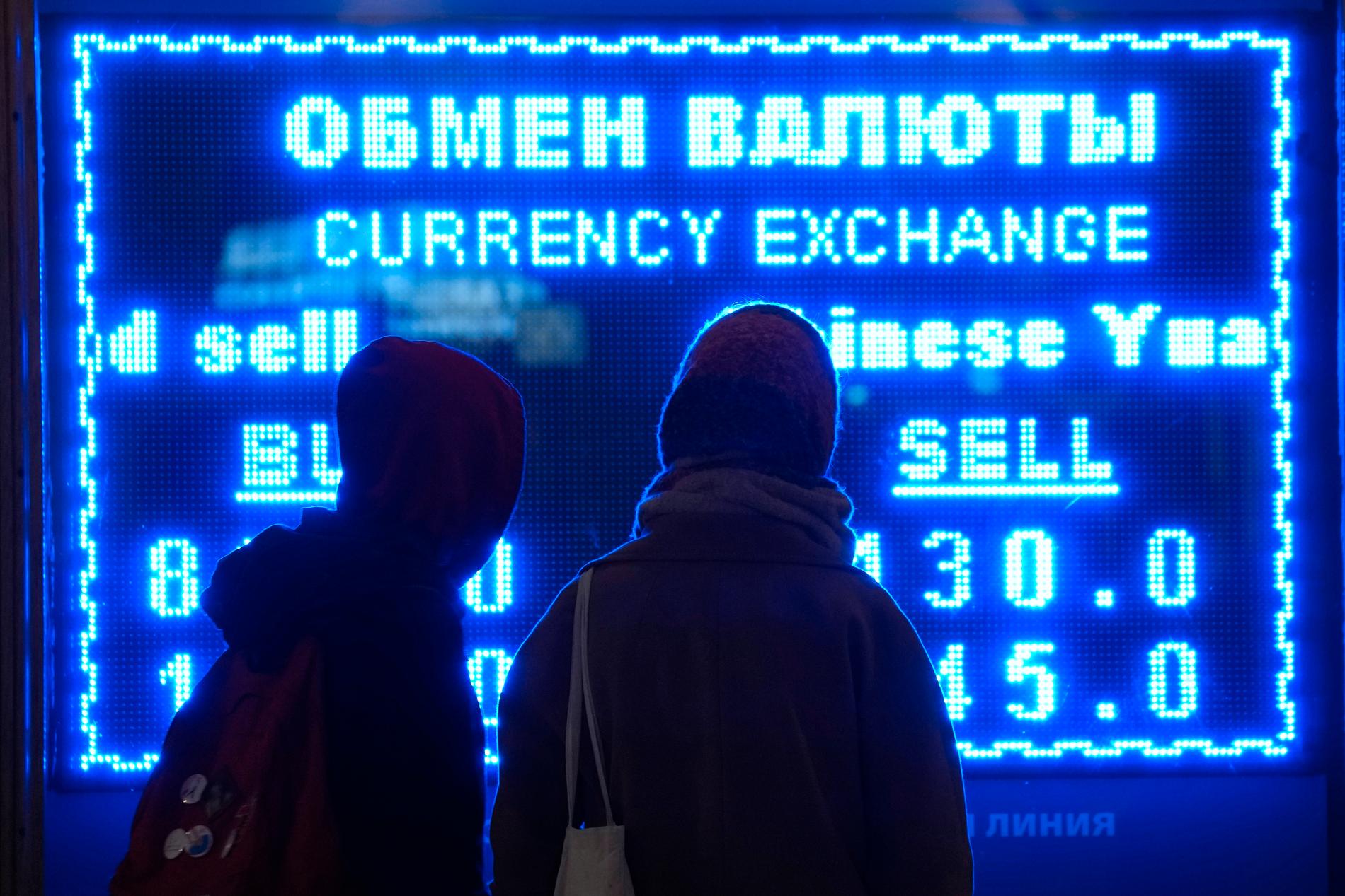 Två kvinnor håller koll på valutakurserna vid ett växelkontor i S:t Petersburg.