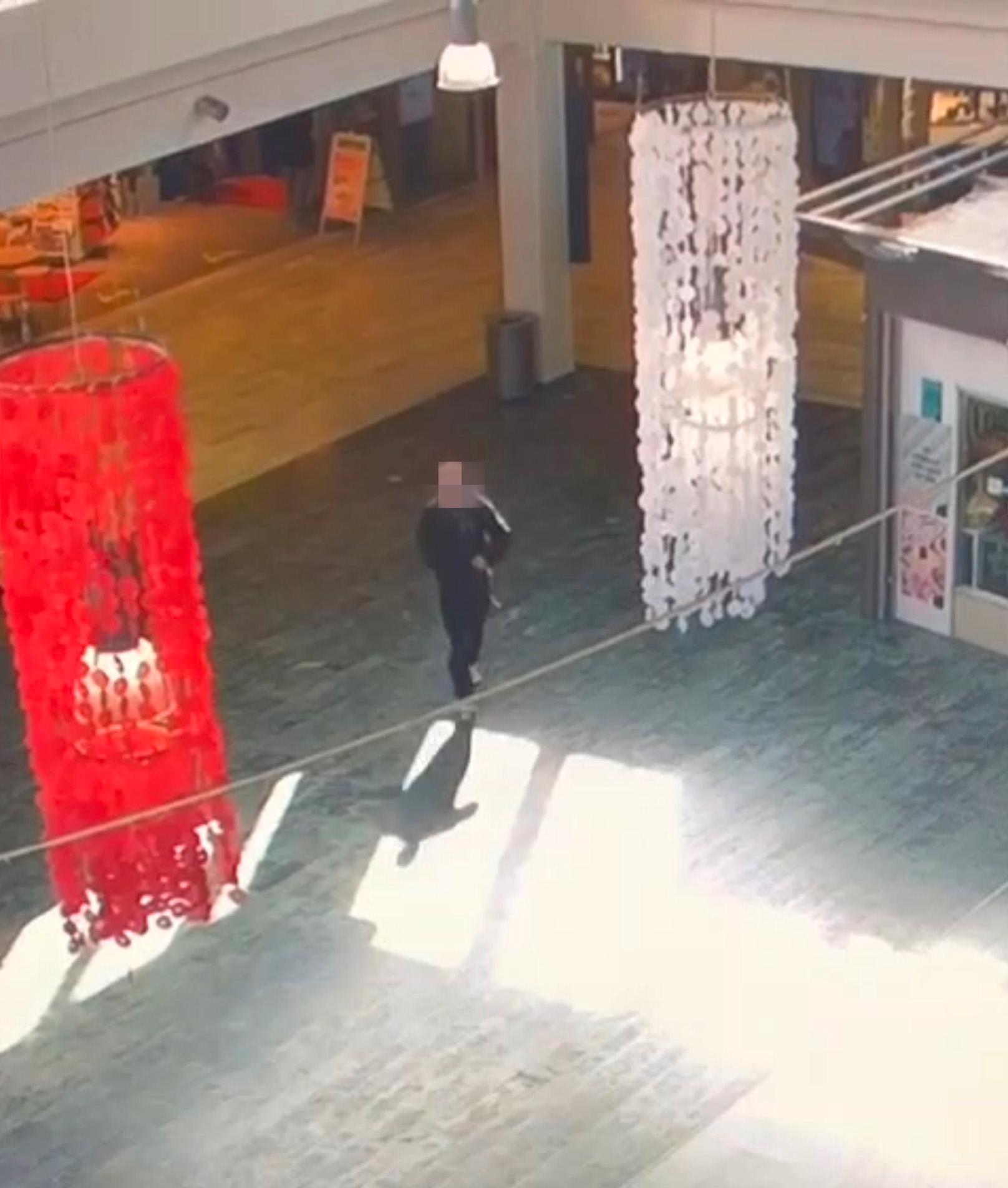 Mannen syns vandra genom ett köpcentrum på övervakningsfilmer. 