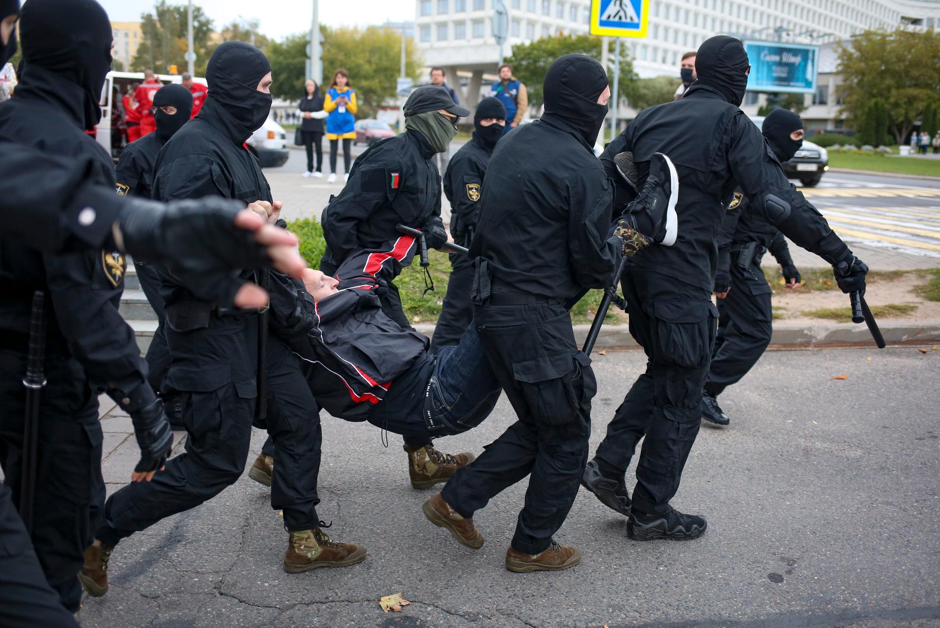 Polisen i Belarus griper en demonstrant i Minsk under söndagens massprotest.
