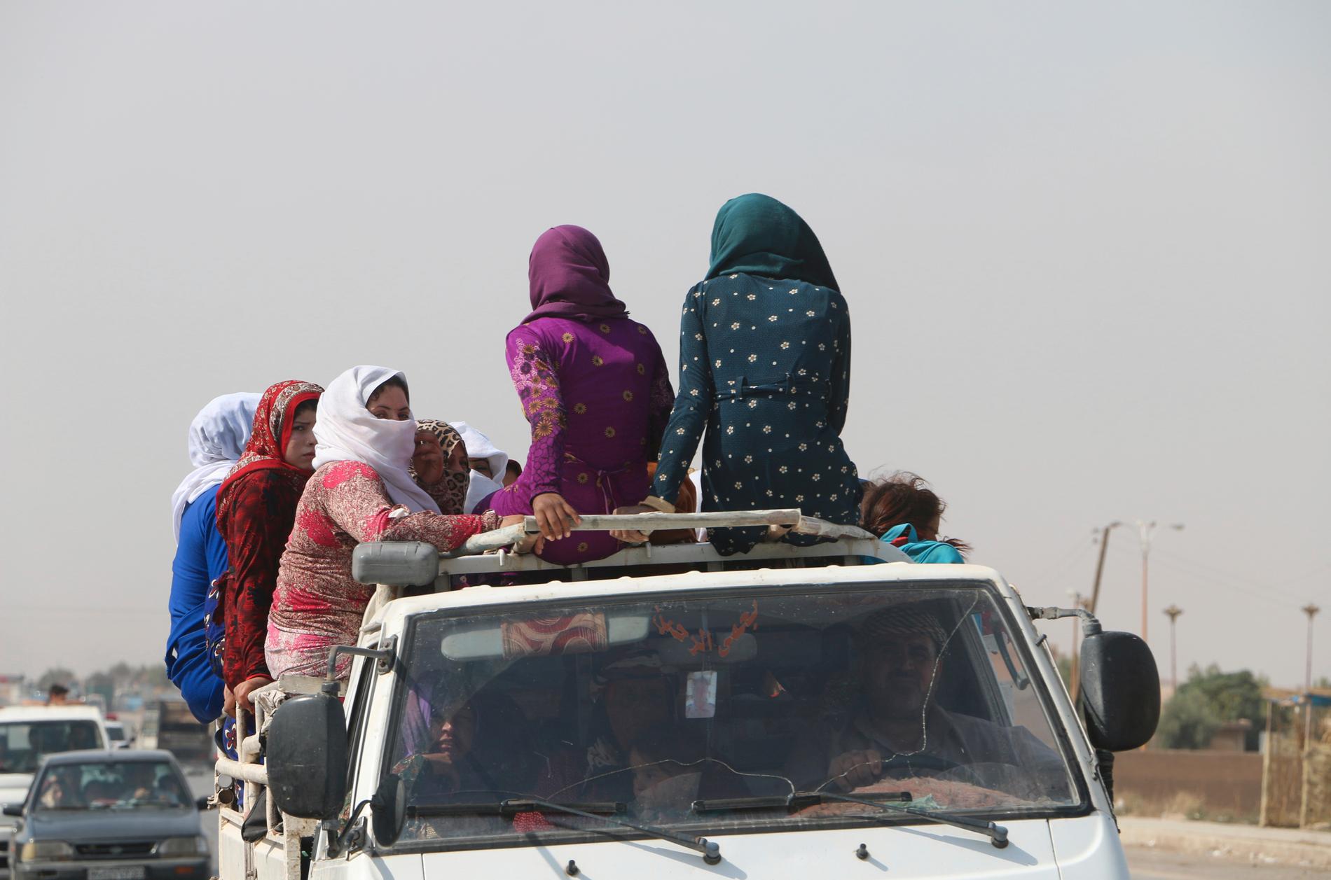 Kvinnor färdas längs en väg i närheten av al-Hasakah, omkring 10 mil söder om gränsen mot Turkiet, i fredags.
