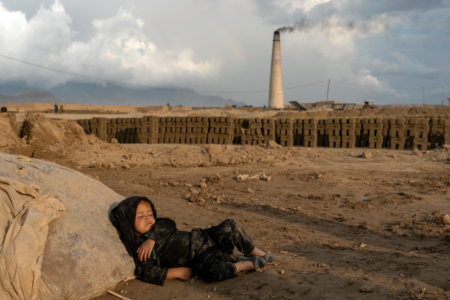En fyraårig flicka vilar efter slutfört arbete på en tegelfabrik i utkanten av Kabul.