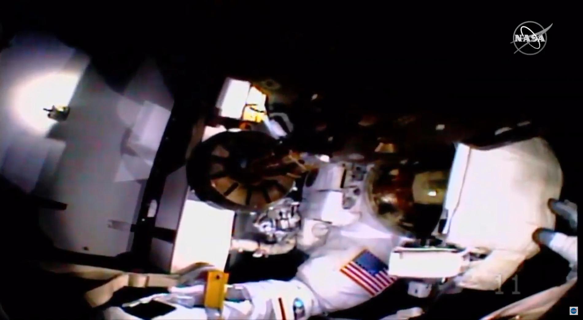Här hjälps astronauterna år sedan videokameran och ljuset på Christina Kochs hjälm lossnat. Jessica Meirs handske syns till höger vid hjälmen.