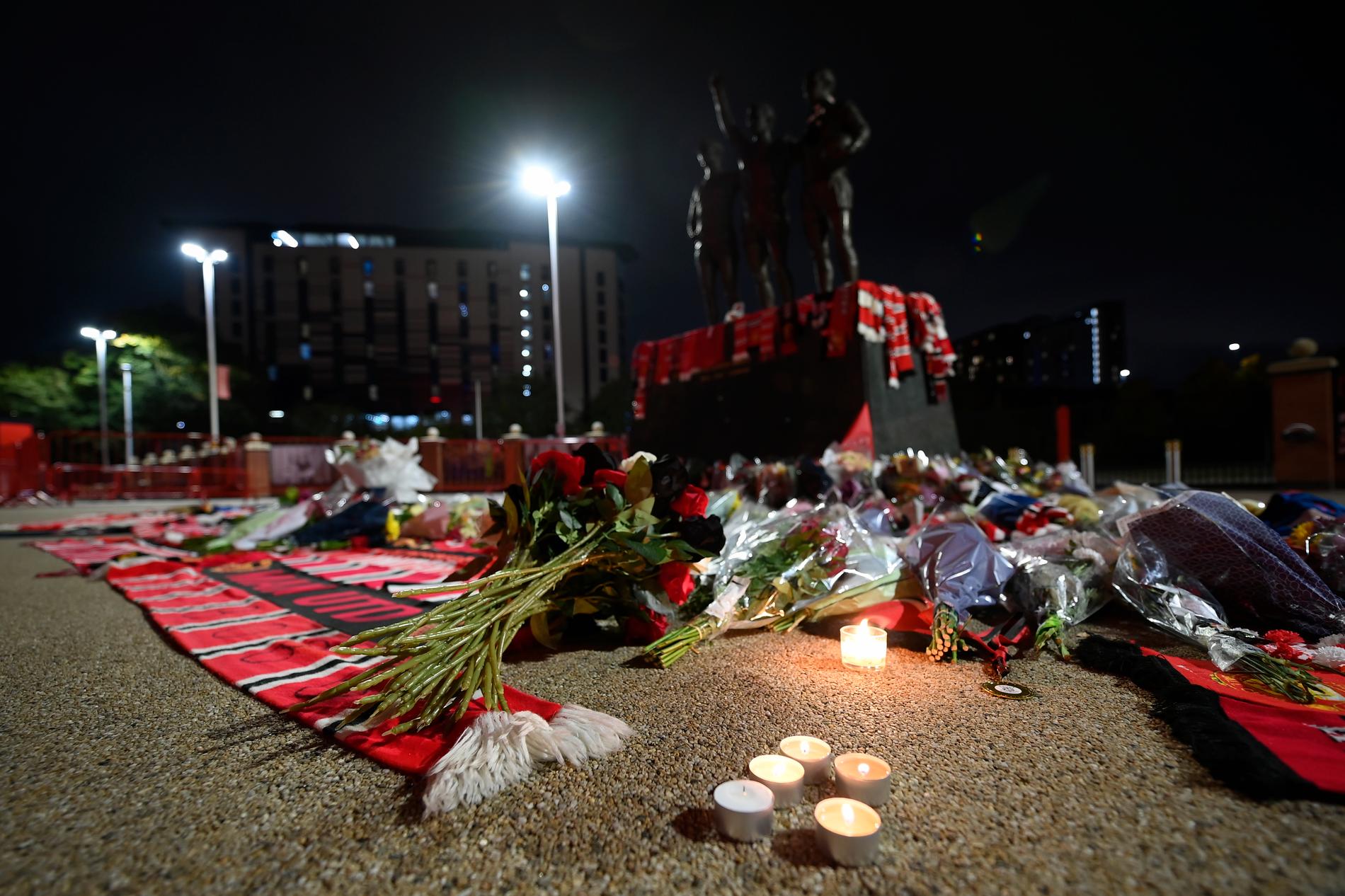 Fans med kondoleanser intill Bobby Charltons staty utanför Old Trafford.
