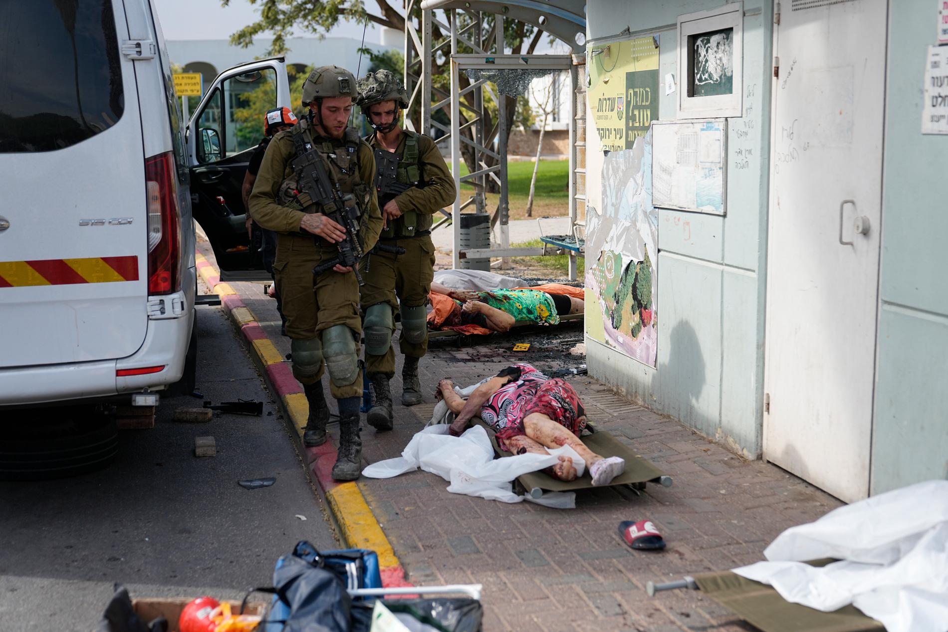 Israeliska soldater går förbi döda civila efter Hamas raketattacker i Sderot, Israel, den 7 oktober, 2023.