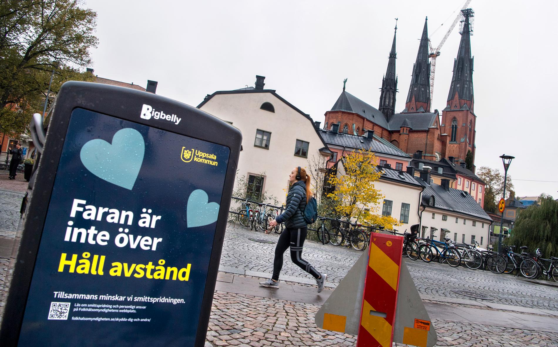En affisch från Uppsala kommun som uppmanar att hålla avstånd och att faran inte är över när det gäller smittspridningen.