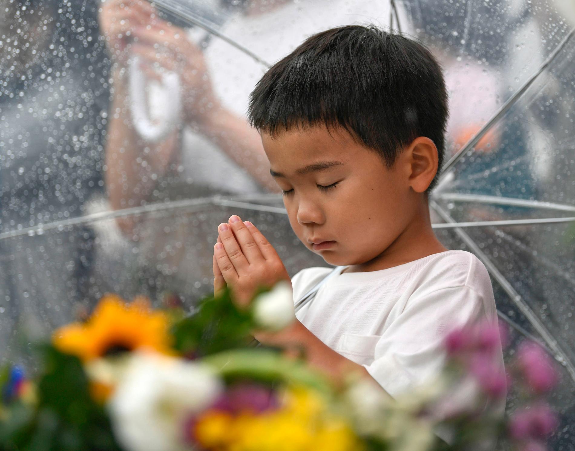 En liten pojke deltar i minnesceremonin.