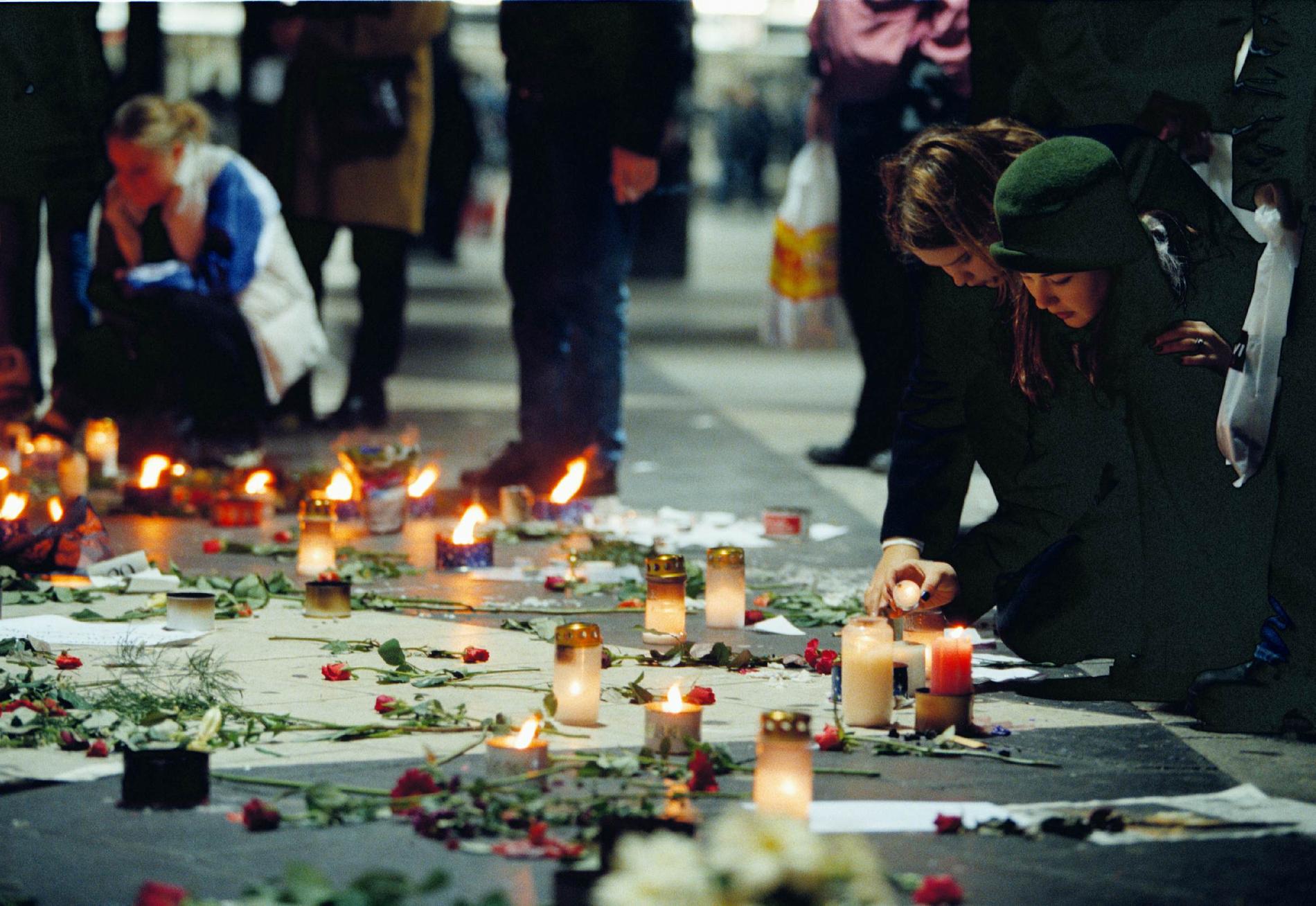 Blommor och tända ljus på Sergels torg i Stockholm för att hedra offren i branden. 