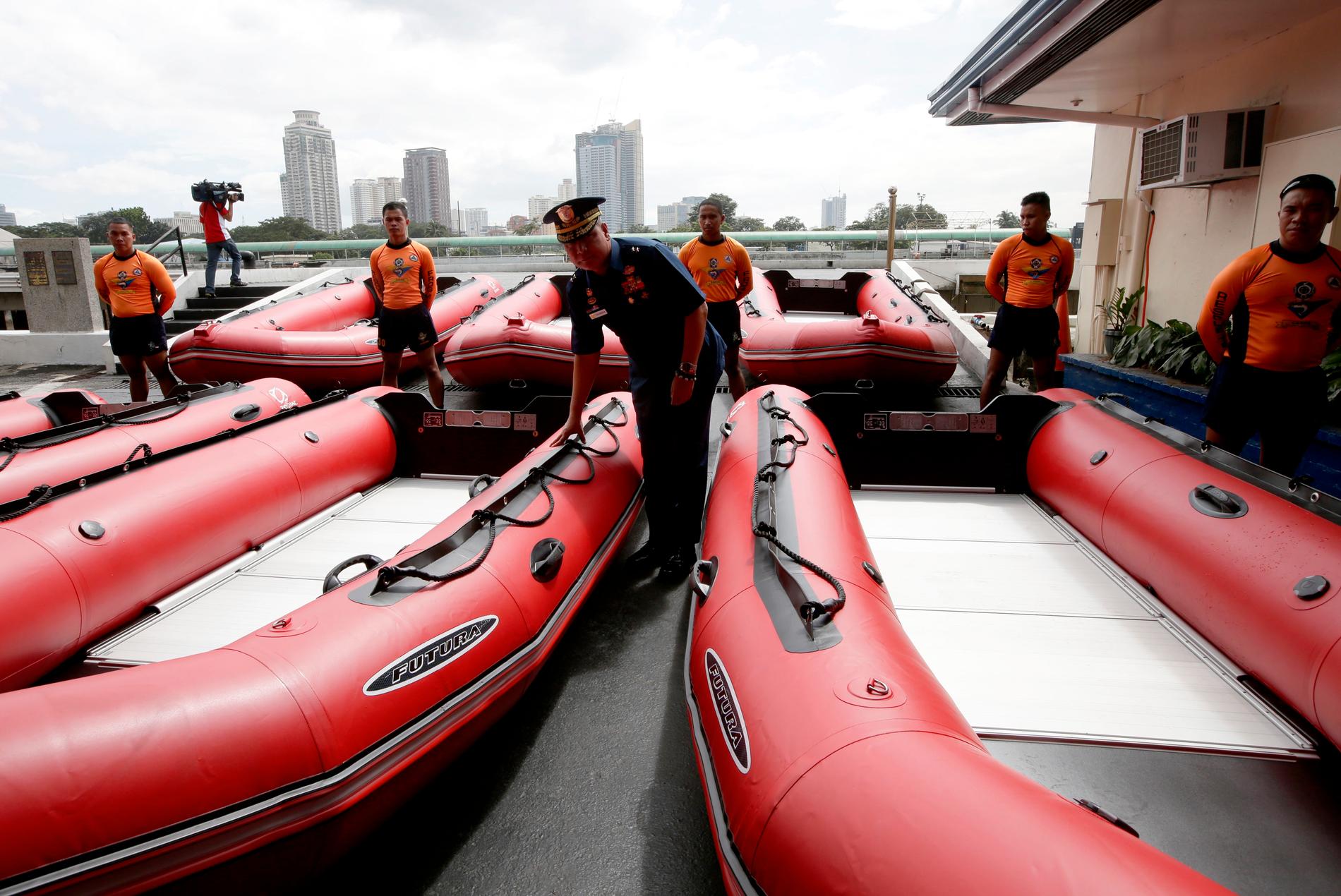 Kustbevakningschefen kontrollerar nya gummibåtar i Manila.