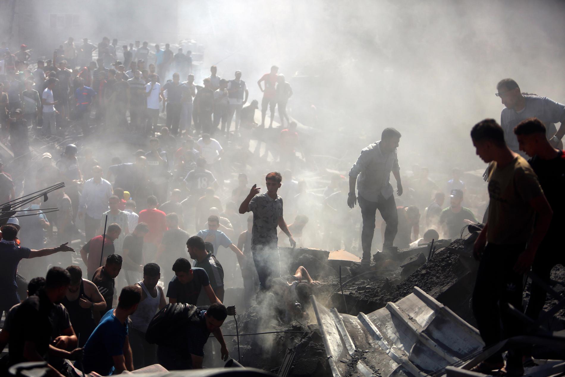 Palestinier söker i rasmassorna vid staden Khan Younis efter Israels flyganfall, den 26 oktober, 2023.