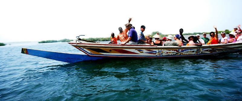 FLYTANDE MÖTE.”På väg ut i träsket möter vi en annan båt. Tack vare ekoturismen har Sine Saloum fått en framtid och skövlingen av träsket har stoppats upp. Fiskarna fyller nu sina fiskebåtar med turister i stället för utrotningshotade fiskarter.”