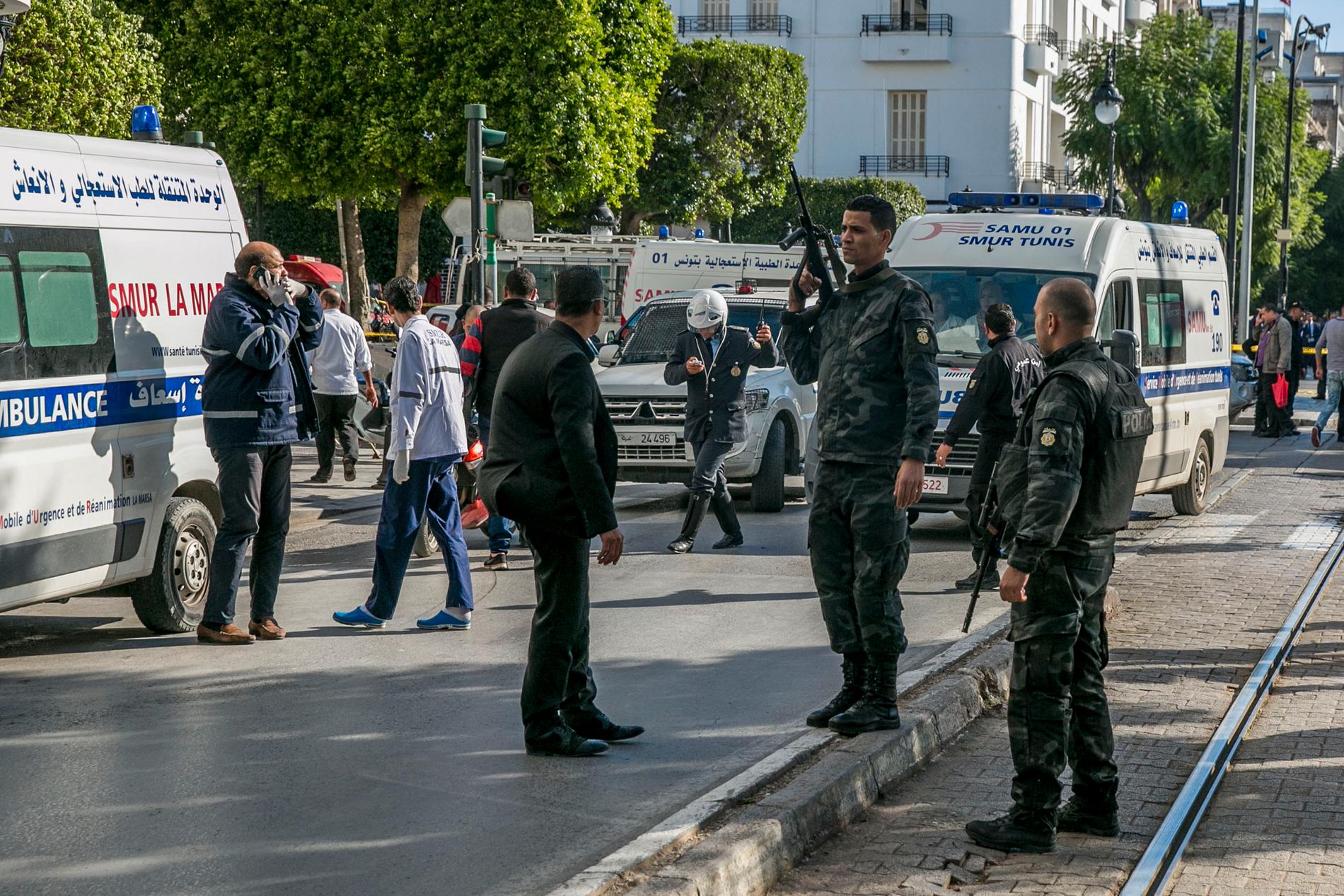 Tunisiska poliser och ambulanspersonal vid platsen för bombdådet.