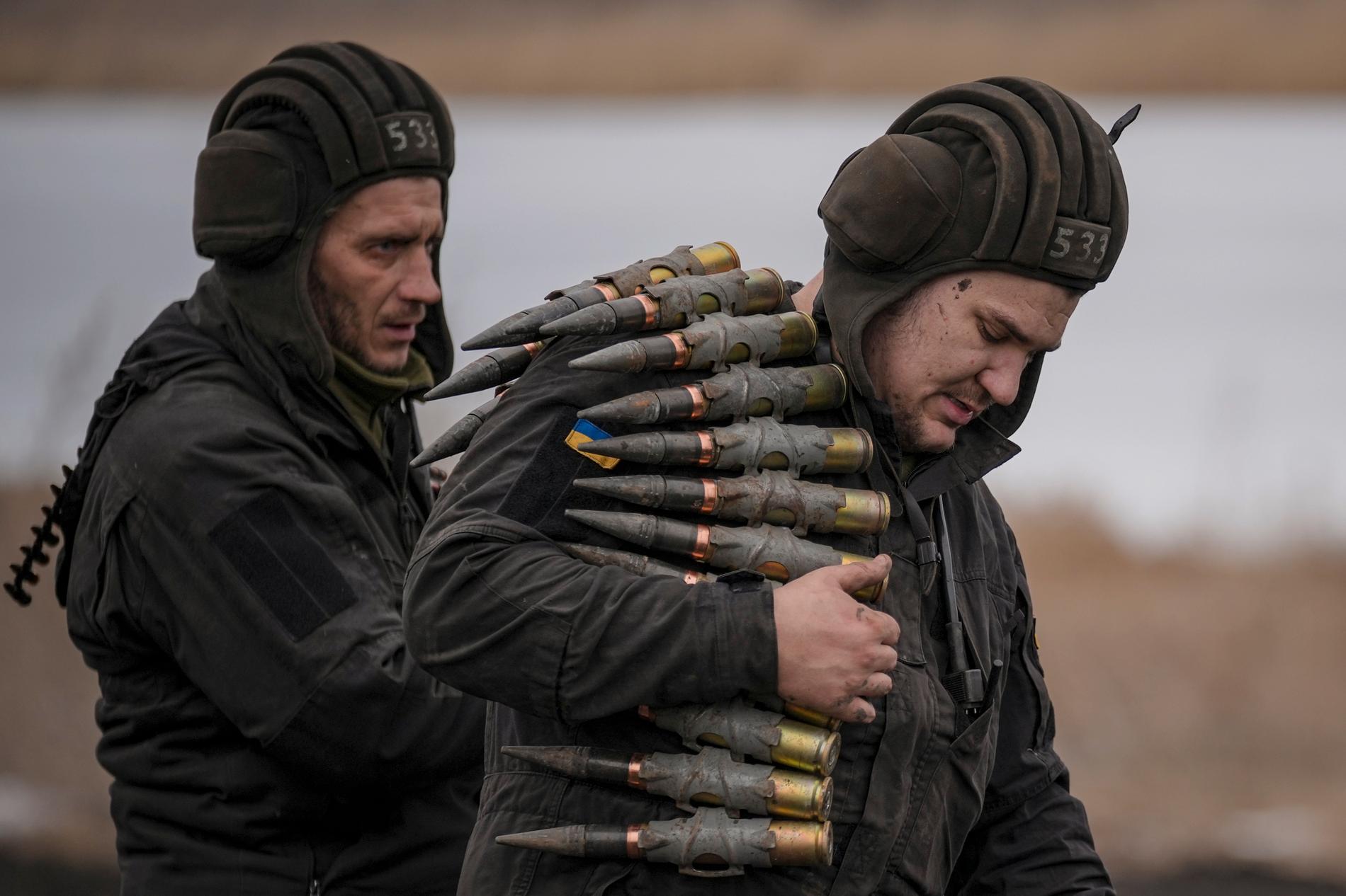 Ett par ukrainska soldater bär på grovkalibrig ammunition  i östra Ukraina.  
