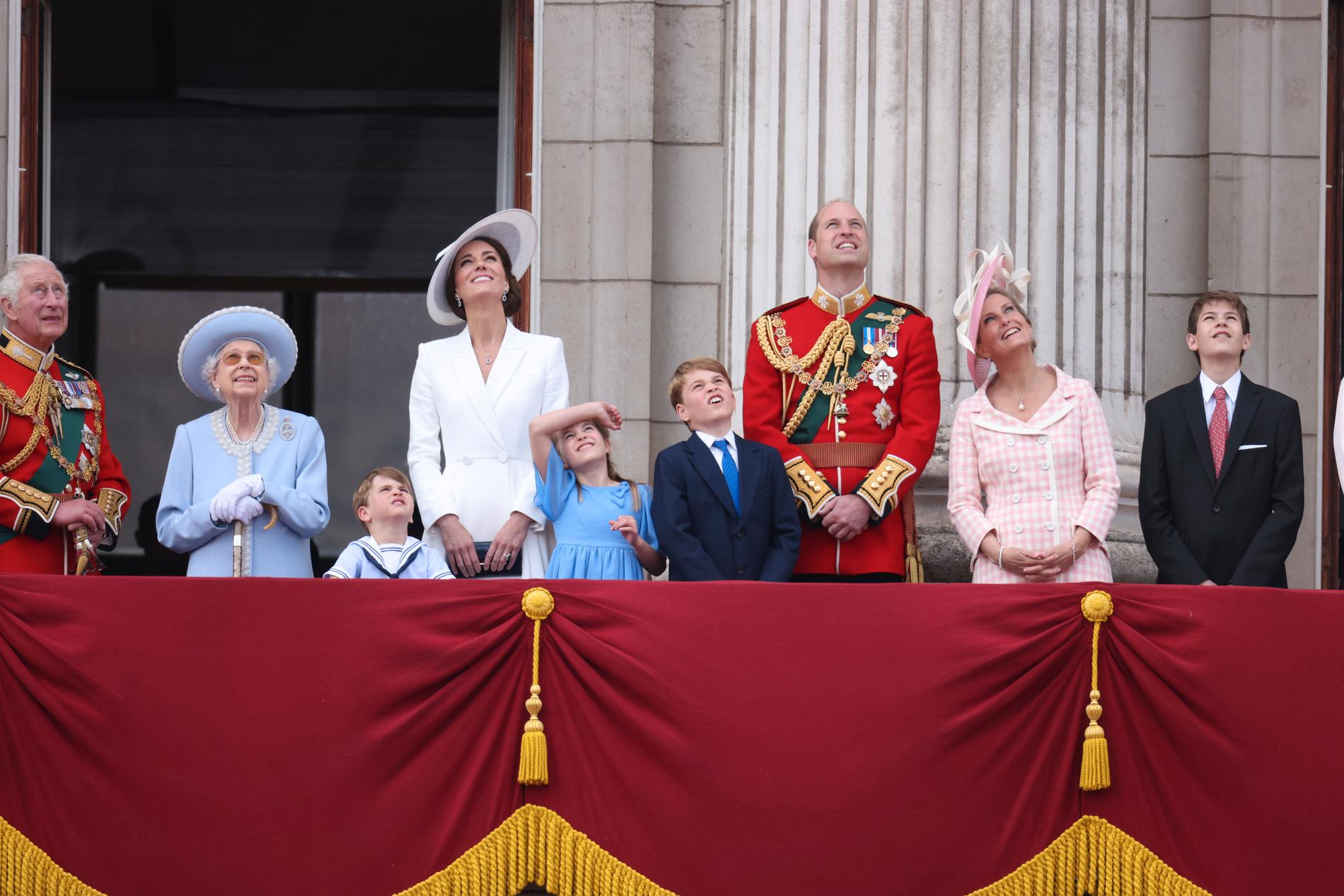 Drottningen och hennes familj. Från vänster prins Charles,  Elizabeth II, prins Louis, hertiginnan Catherine ”Kate” av Cambridge, prinsessan Charlotte, prins George, prins William, grevinnan Sophie av Wessex och viscount Severn.