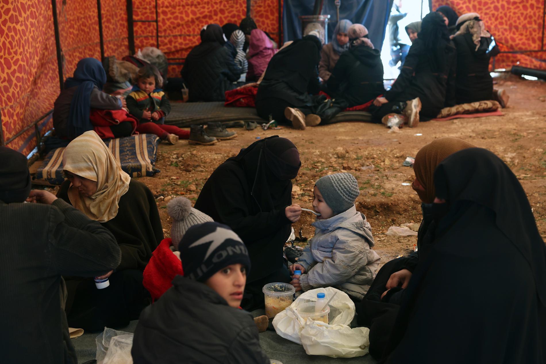 Familjer som förlorat sina hem sitter i en hjälporganisations tält i staden Harem i Idlib-provinsen i Syrien.