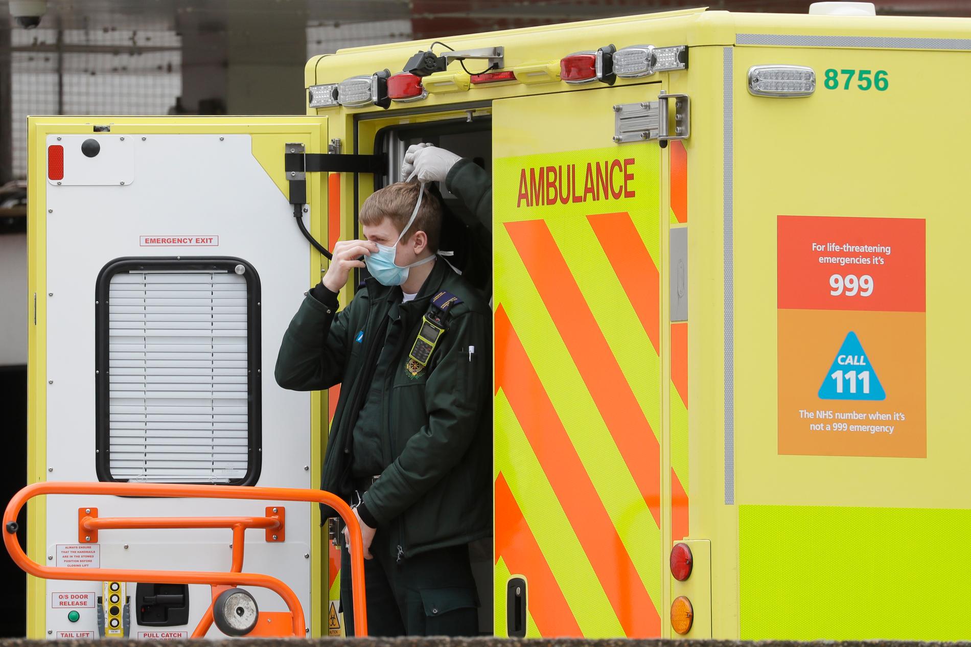 En vårdanställd får hjälp av en kollega att få på sig ett munskydd, vid ett sjukhus i London.